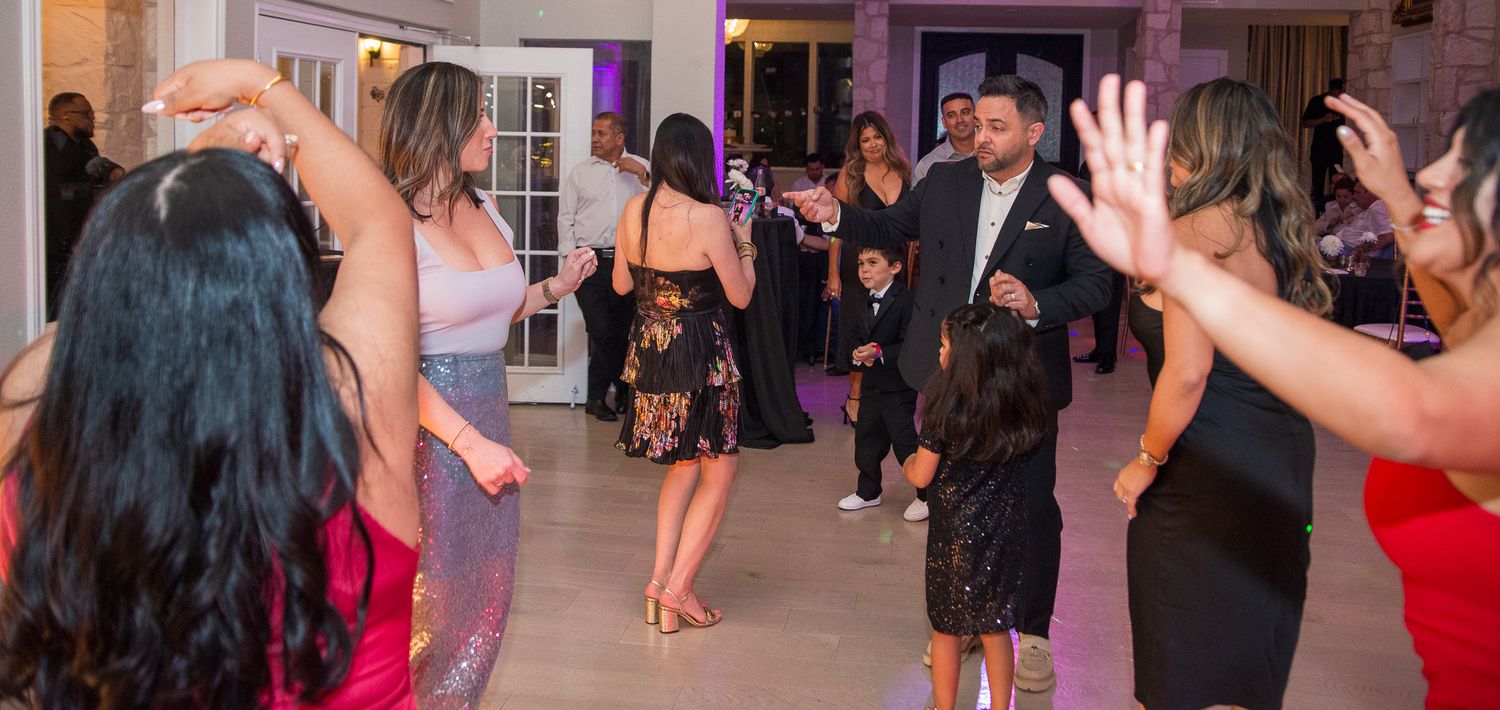 Party guests dancing and celebrating in a brightly lit venue.