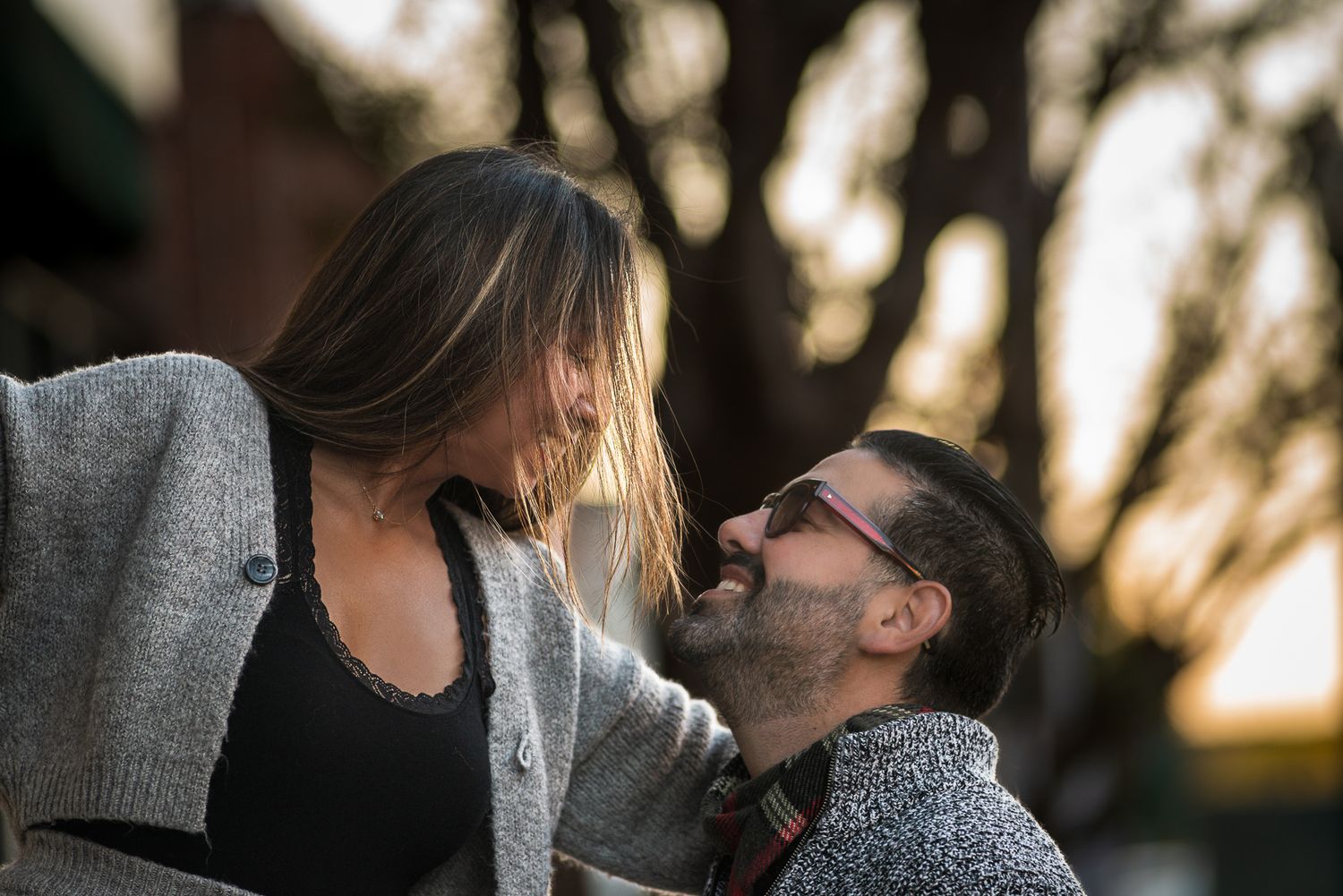 Intimate couple photoshoot with natural lighting through trees.