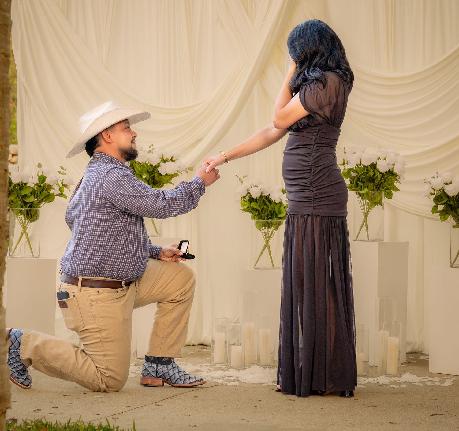 An indoor proposal sequence with elegant white draping and greenery decorations.