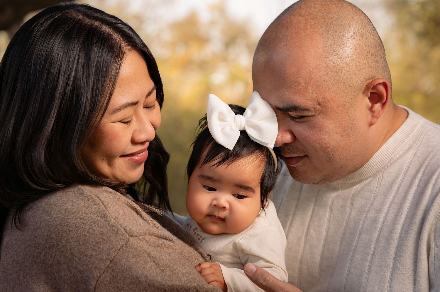Intimate family portraits showing tender moments between parents and baby.