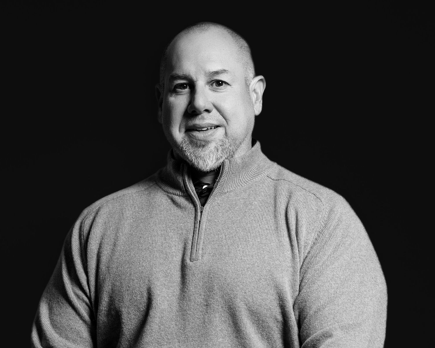 Black and white photo series showing a person in a light colored zip-up sweater making different facial expressions.