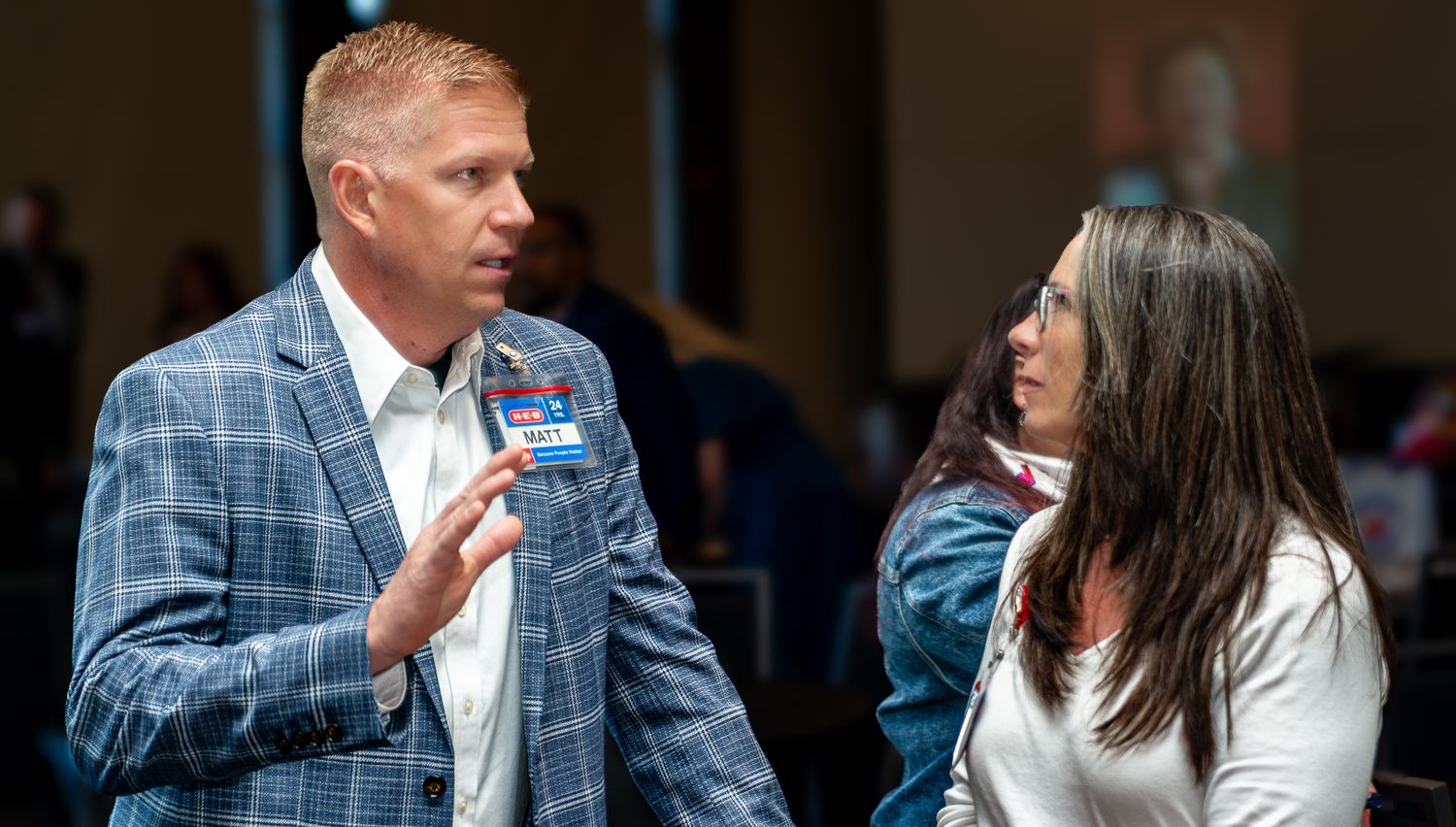 Professional networking event with attendees engaged in conversation.