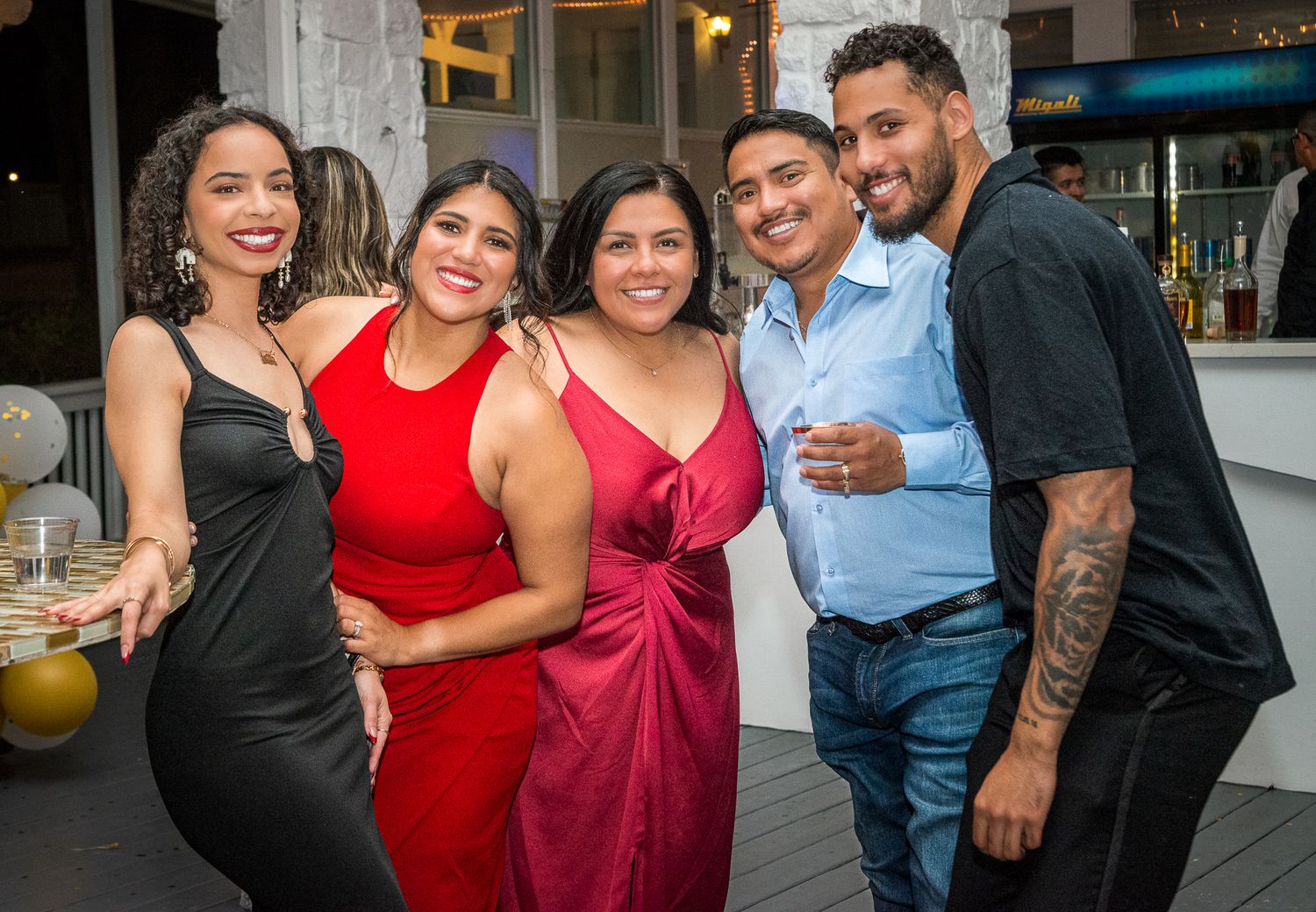 Group of friends in formal attire enjoying a celebration together.