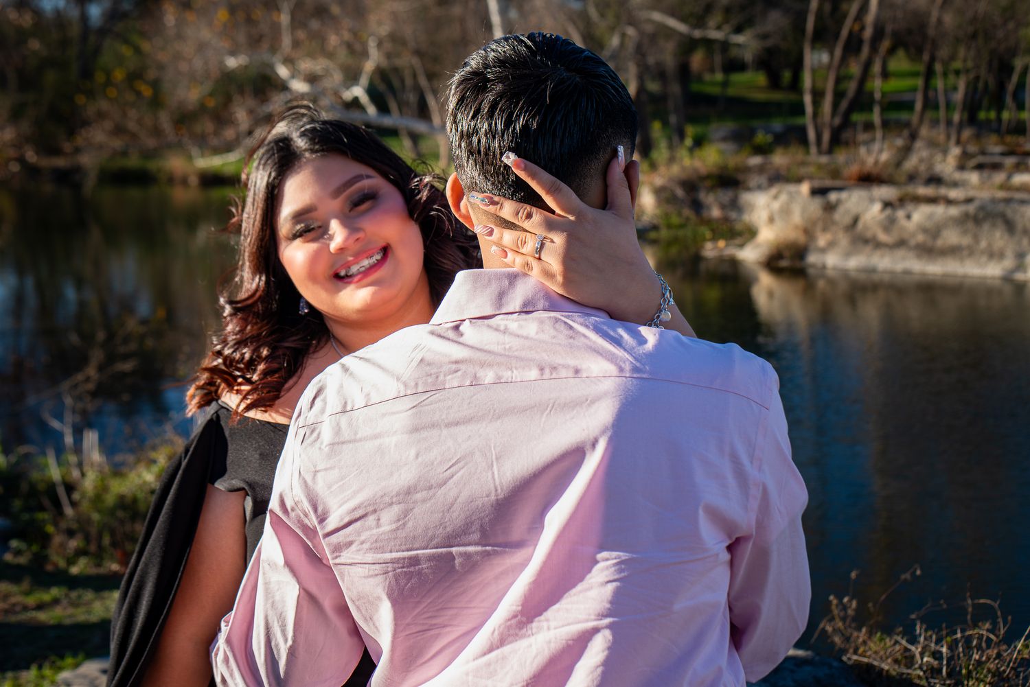 Outdoor engagement photoshoot by a lake during golden hour.