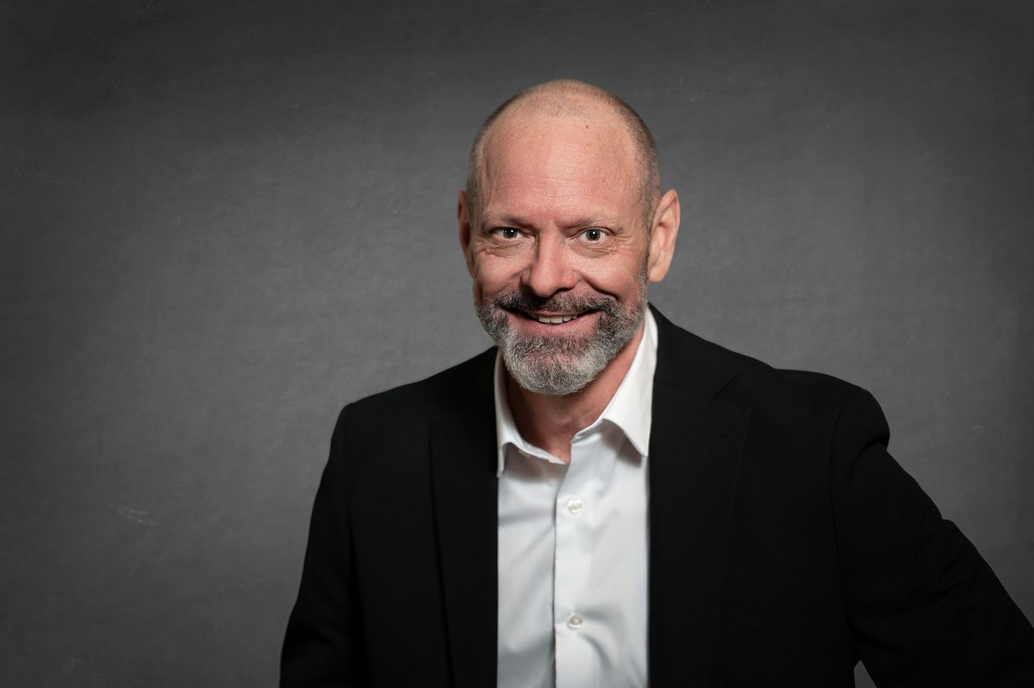 Corporate headshot series featuring person in formal wear with varied expressions.