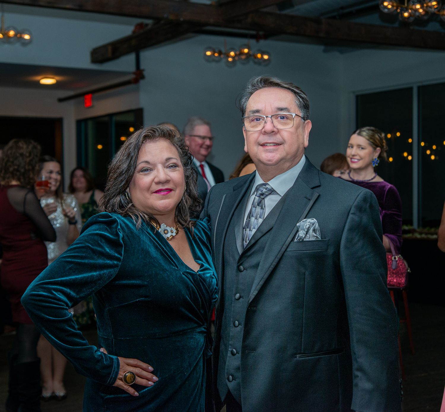 Couple in formal attire at an evening event, wearing velvet and pinstripe suit.