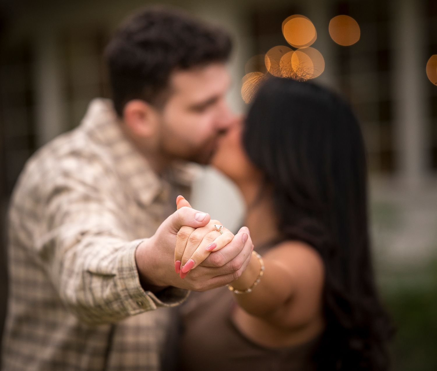 Romantic couples photoshoot with bokeh lights creating a dreamy evening atmosphere.