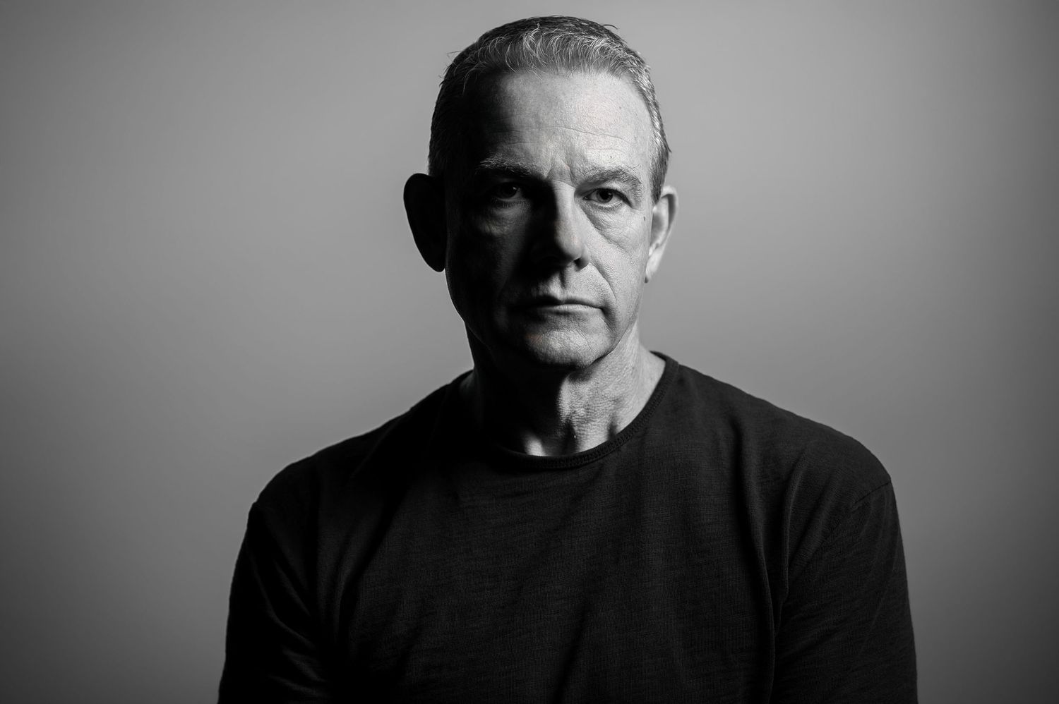 Black and white portrait series showing the same person in six different poses against a dark background.