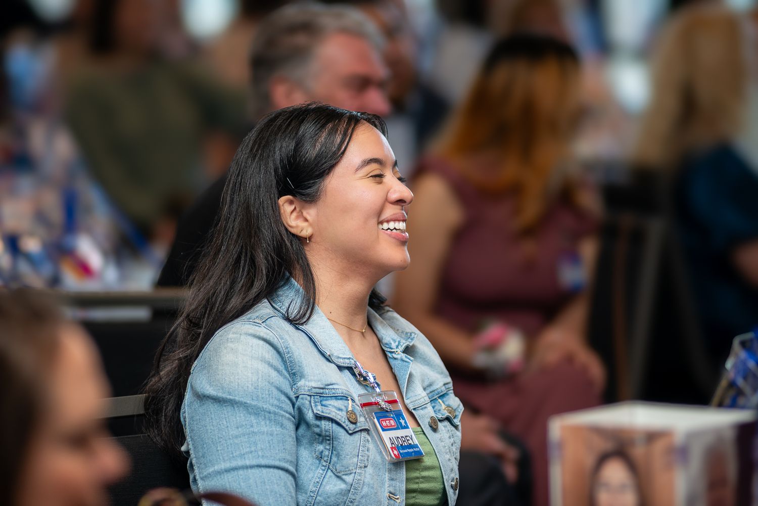 A diverse crowd smiles and laughs during an entertainment event.