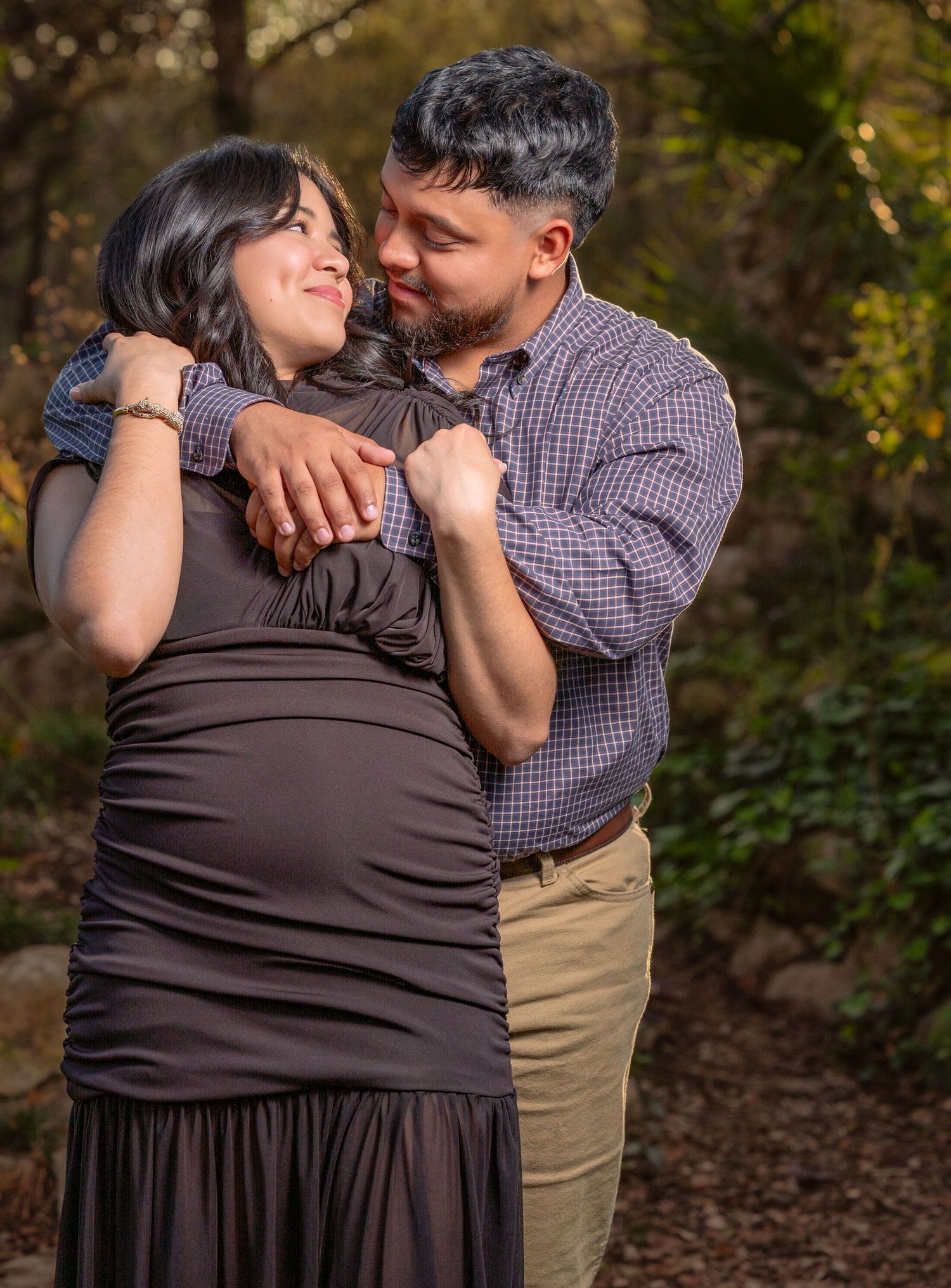 A romantic couple shares an intimate moment outdoors in casual attire.