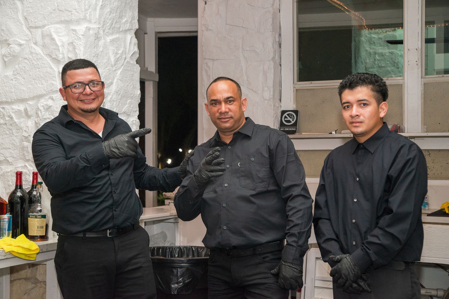 Staff members in black attire serving at an event.