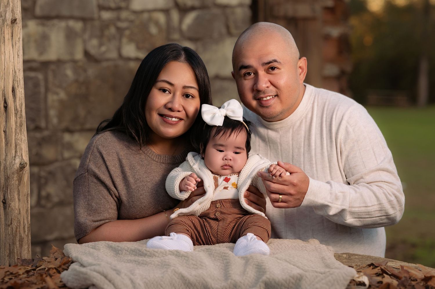 A romantic outdoor family photoshoot with stone architecture and warm lighting at sunset.