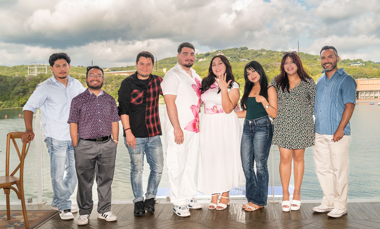 A casual group photo of people standing together by a lakeside.