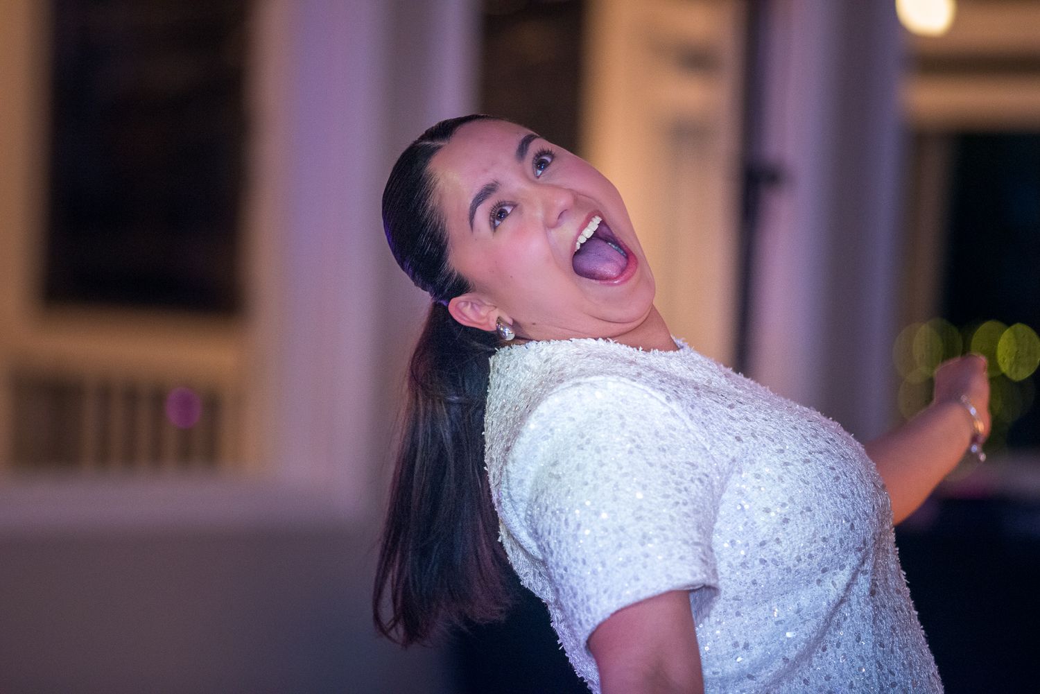 Celebratory event with attendee in white dress showing enthusiastic expressions.