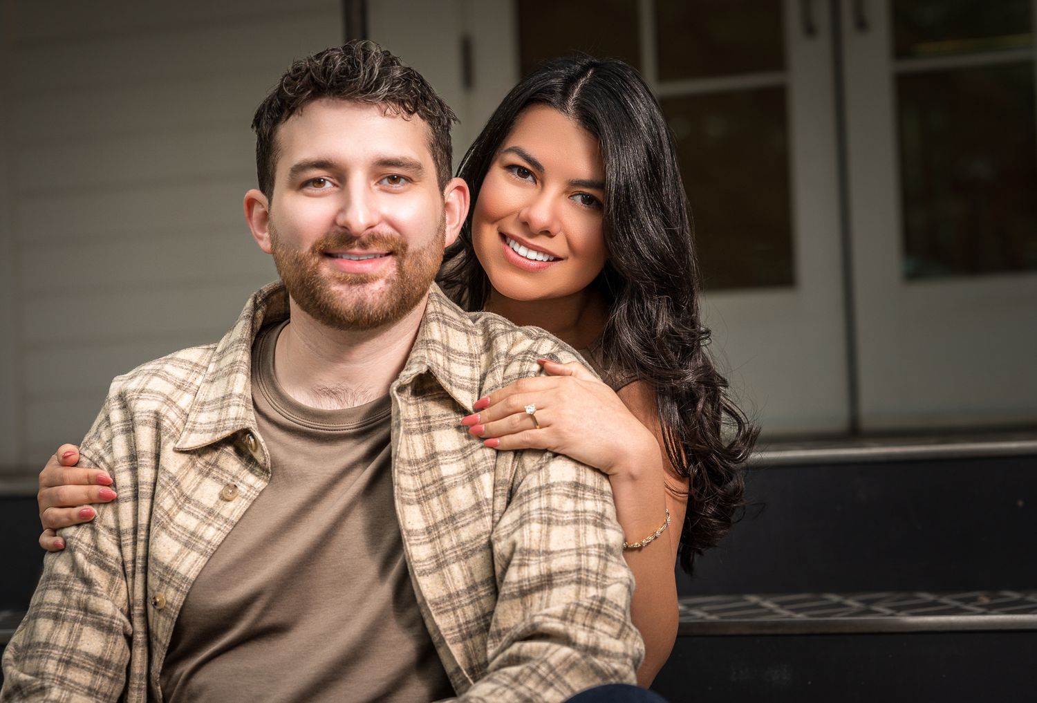 Romantic outdoor engagement photoshoot featuring a couple in coordinated brown and plaid outfits.