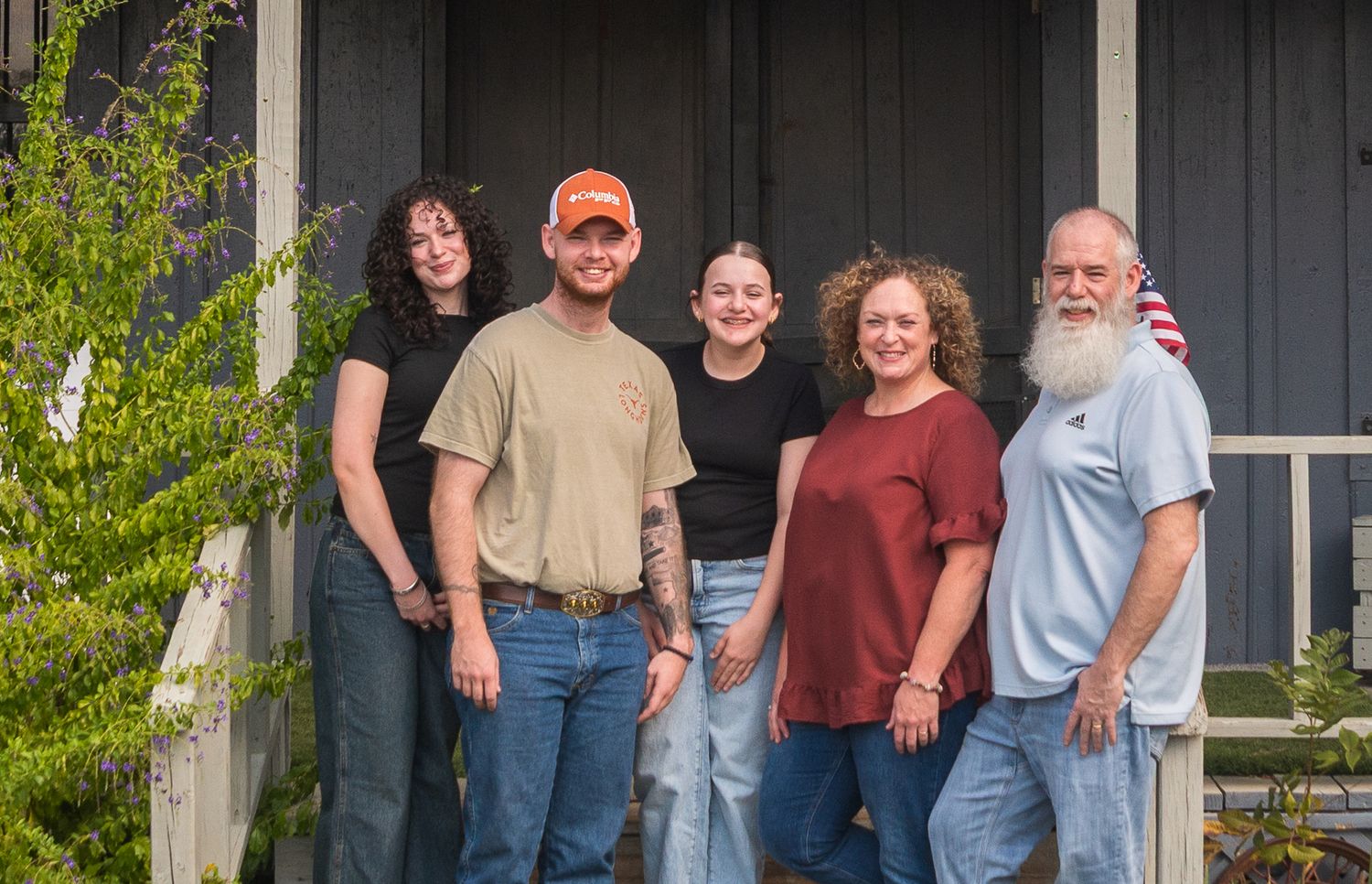 Family members lined up against dark building exterior for group portrait.