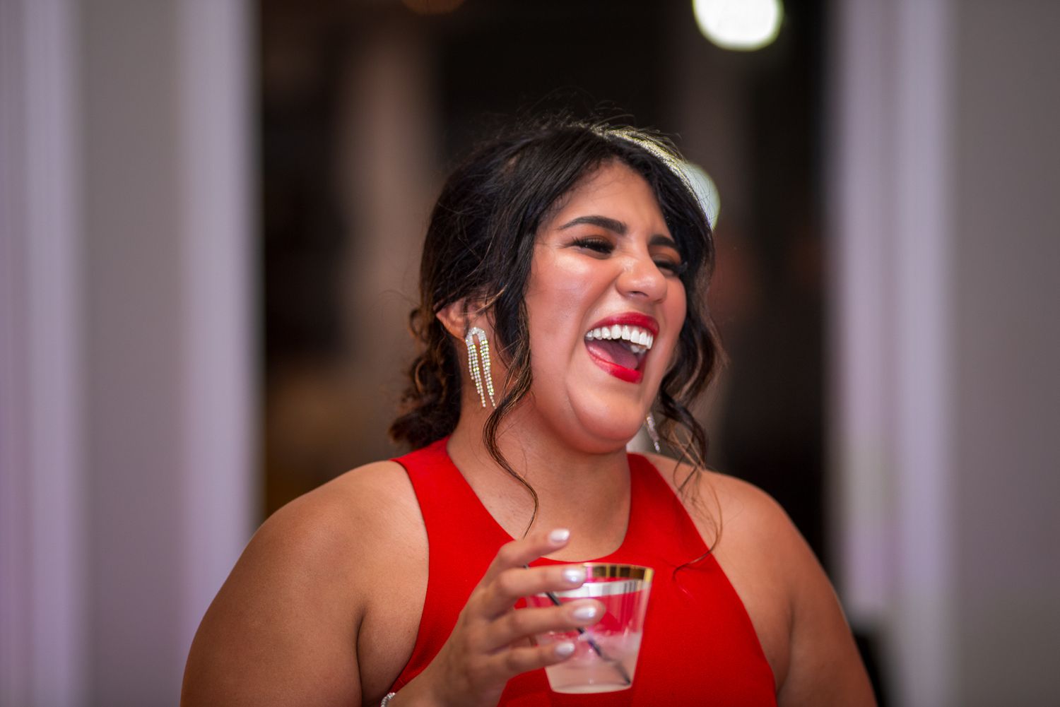 Festive evening party scene with bright smiles and red attire.