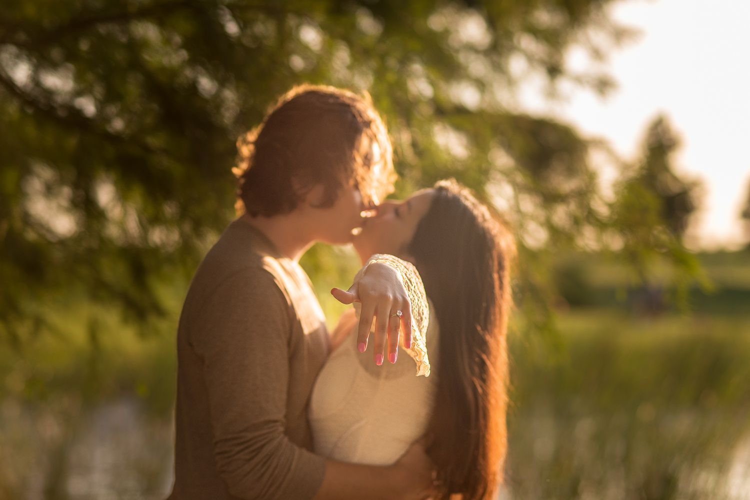 Sunset engagement photography session with golden hour lighting in a natural outdoor setting.