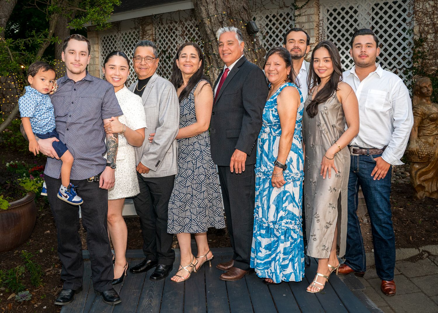 A large family gathering poses together on an outdoor deck.