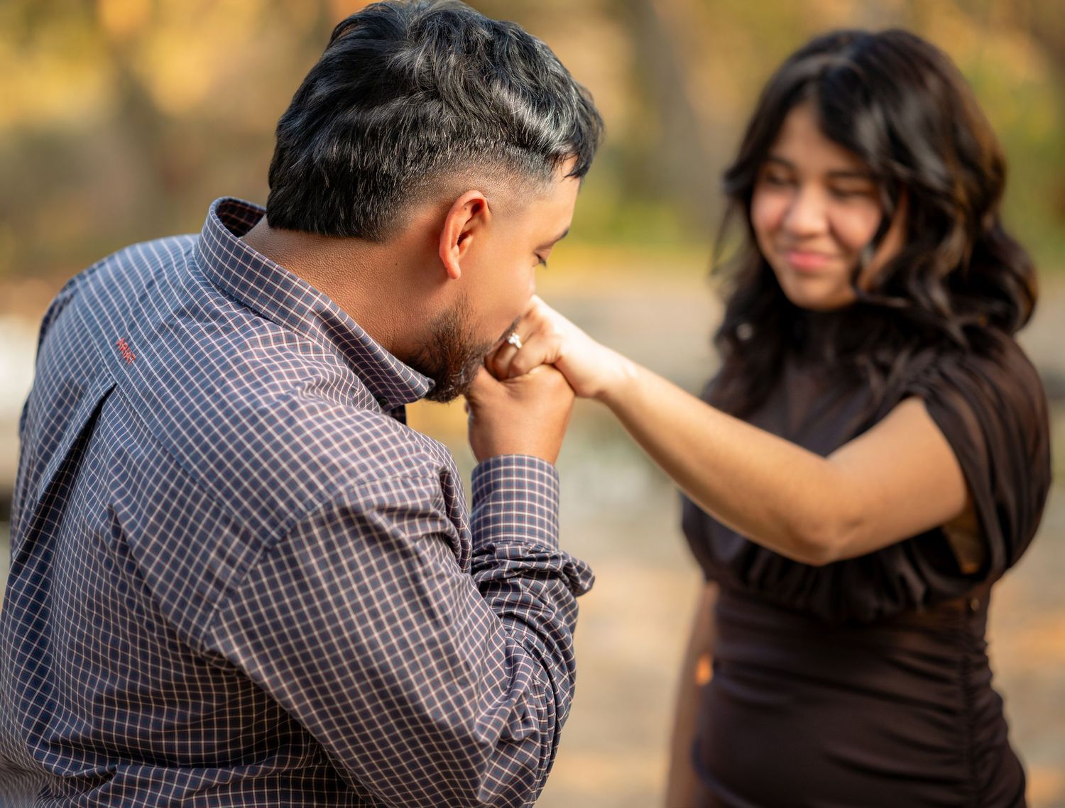 Couple sharing an intimate moment outdoors wearing casual attire.