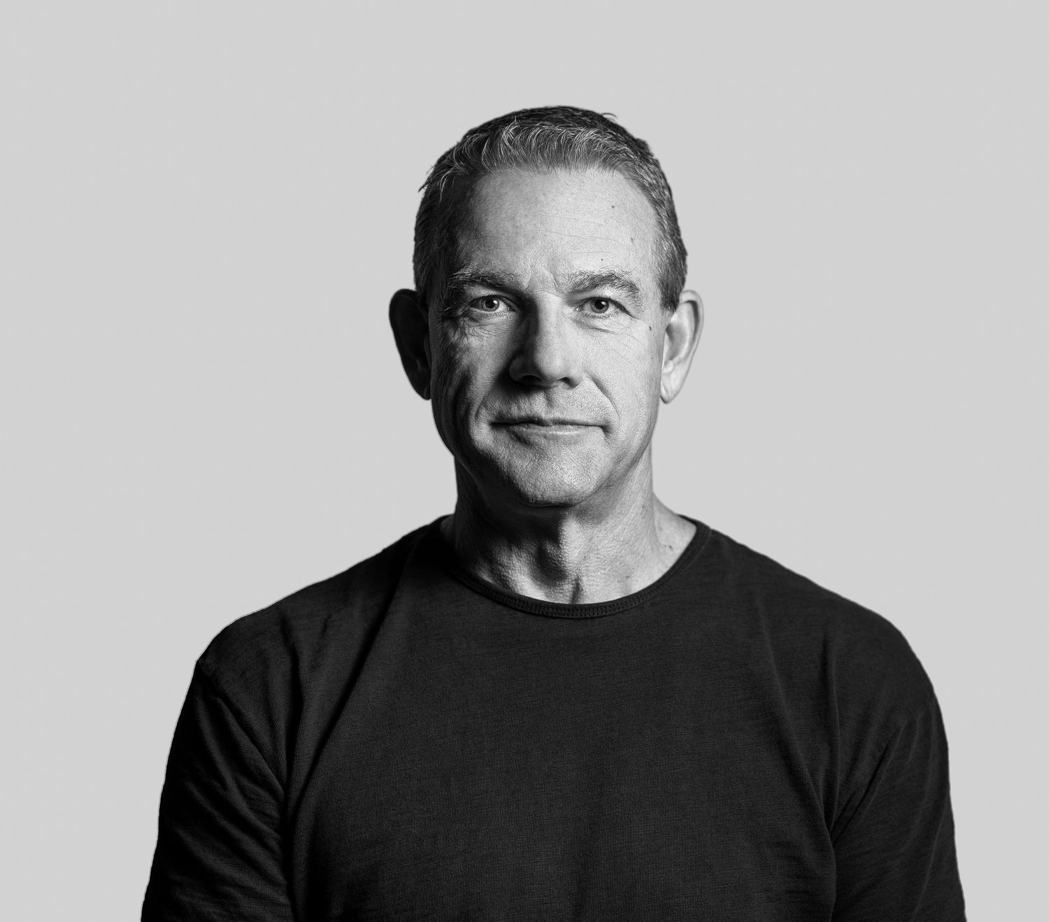 A series of four black and white headshot portraits showing different expressions in a minimalist style.