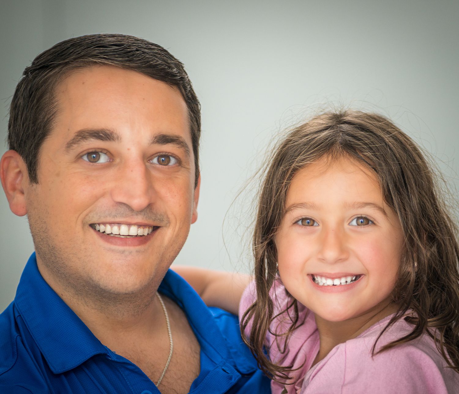 Studio portrait series with warm lighting against a neutral grey background.