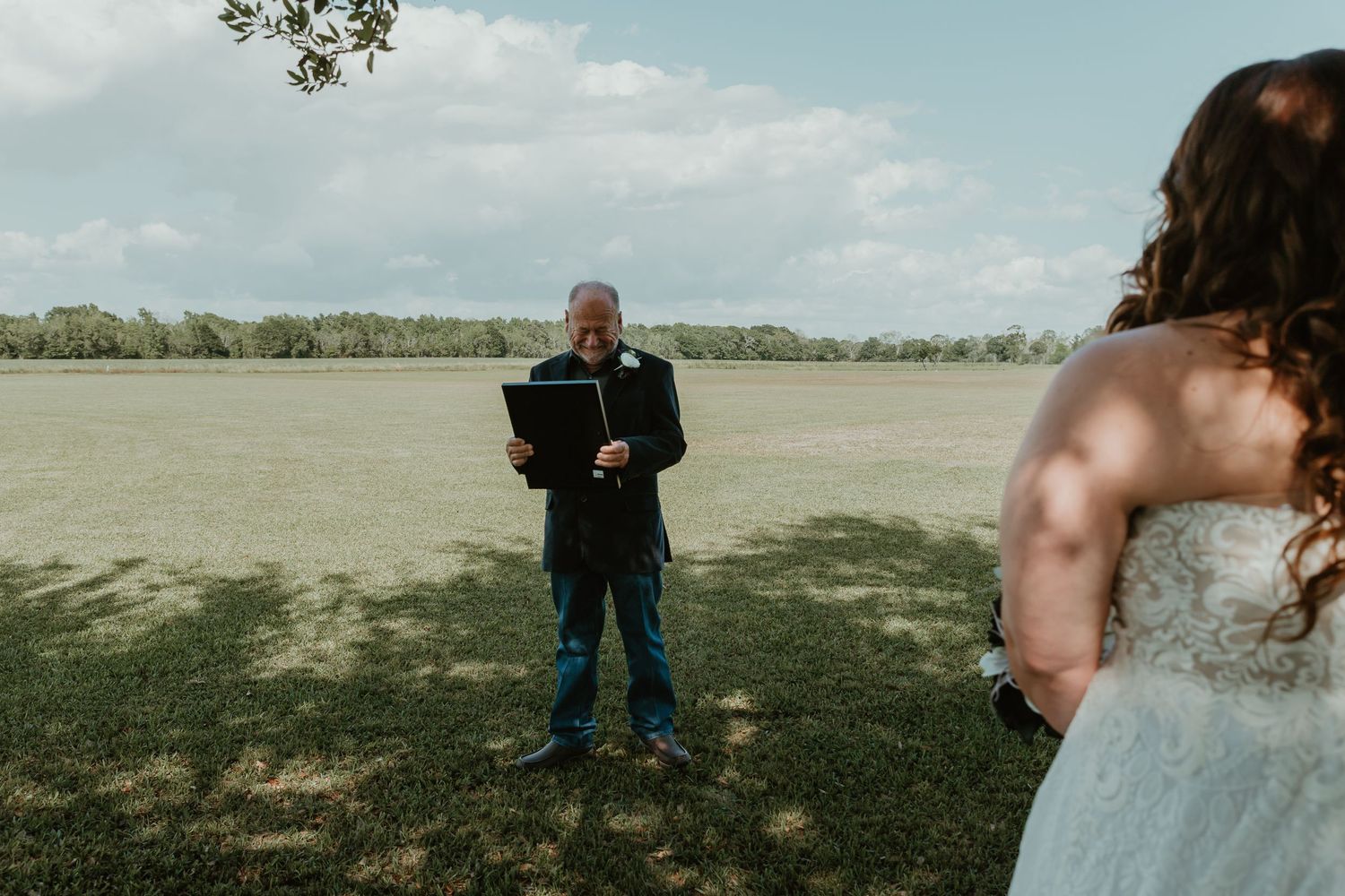 Dad views a young portrait of bride while she stands in front of him on her wedding day.