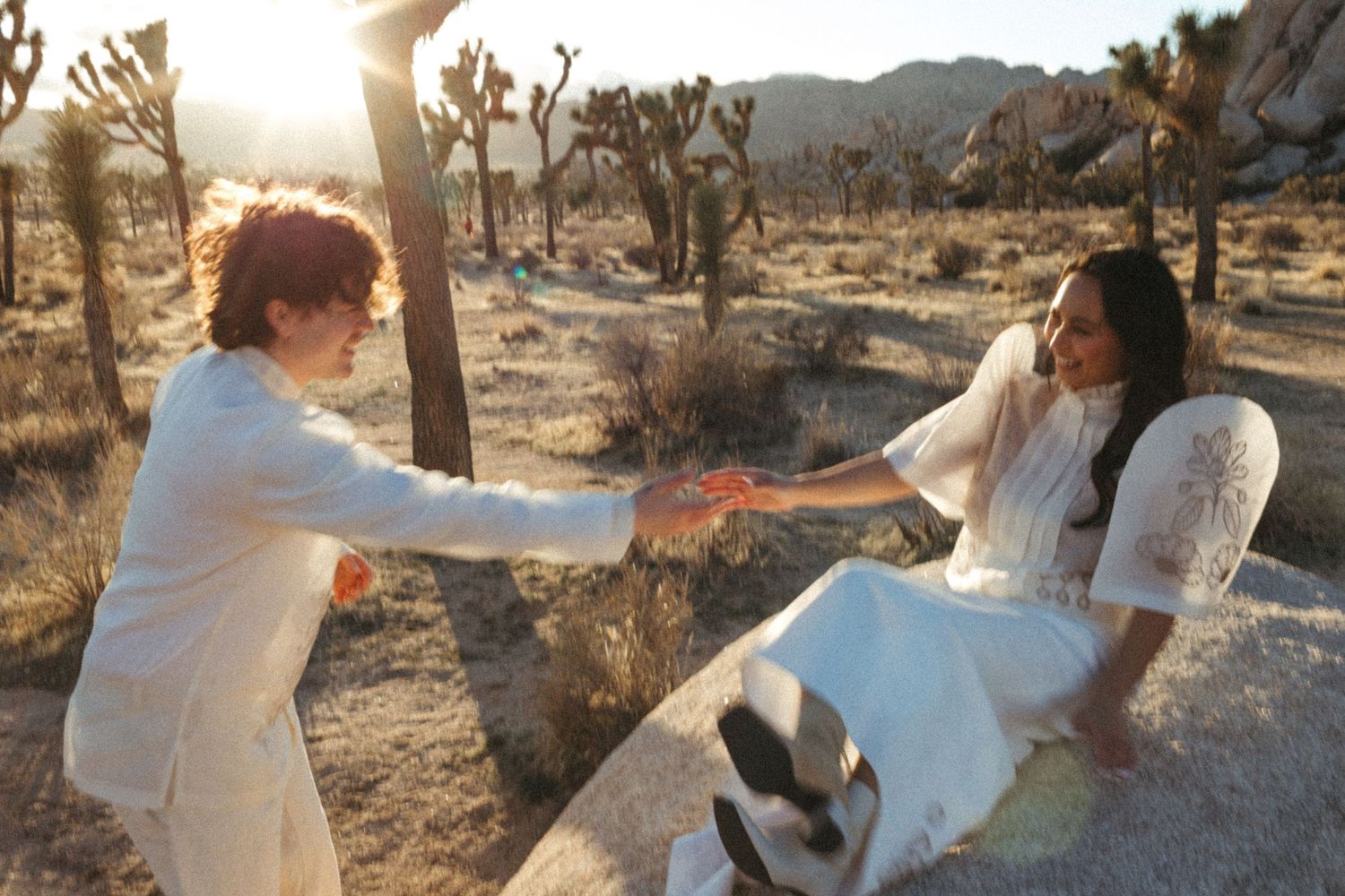photo of couple playing on rocks during golden hour sunset at joshua tree national park near palm springs