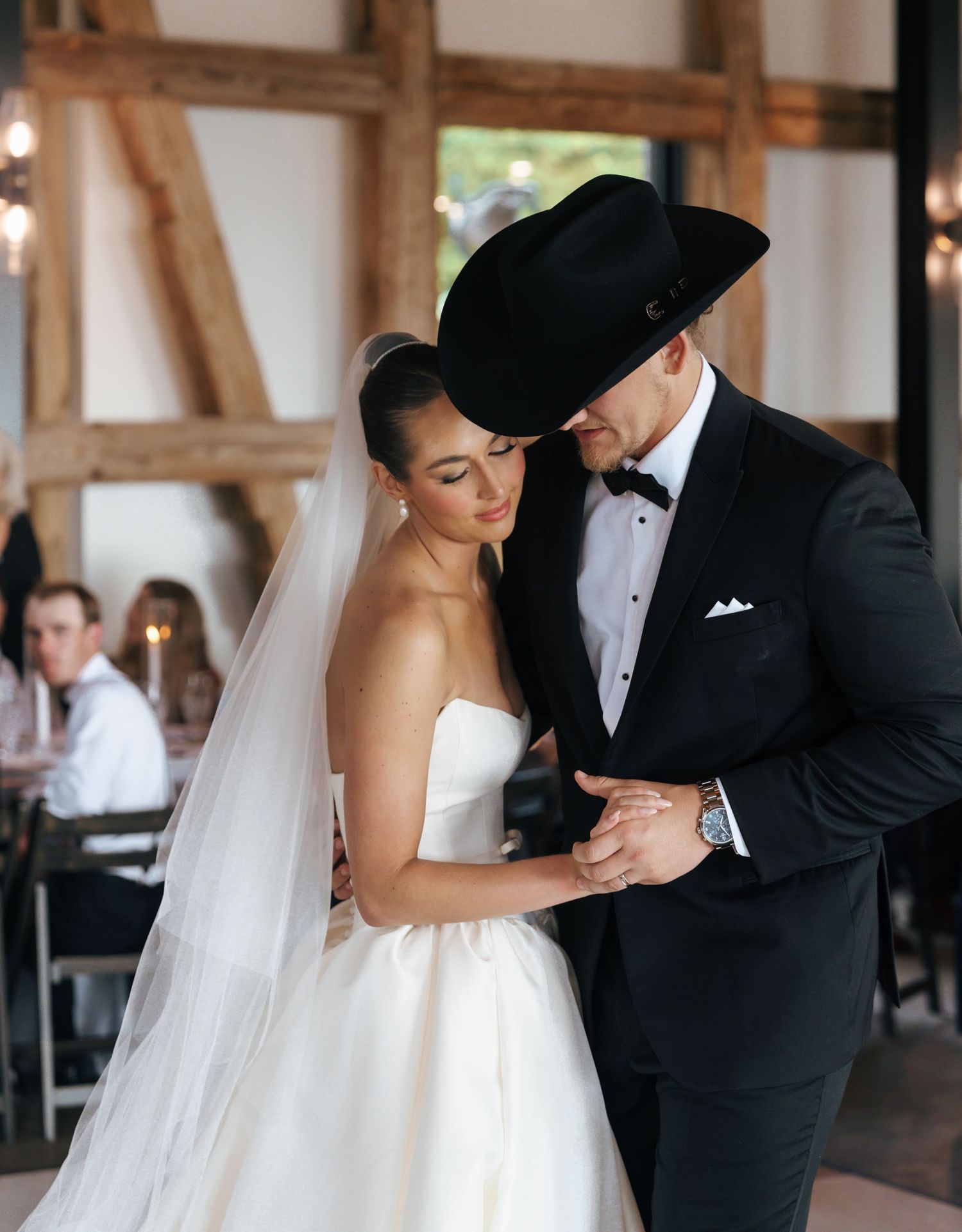 Couple sharing their first dance on a checkered ballroom floor at their wedding reception.