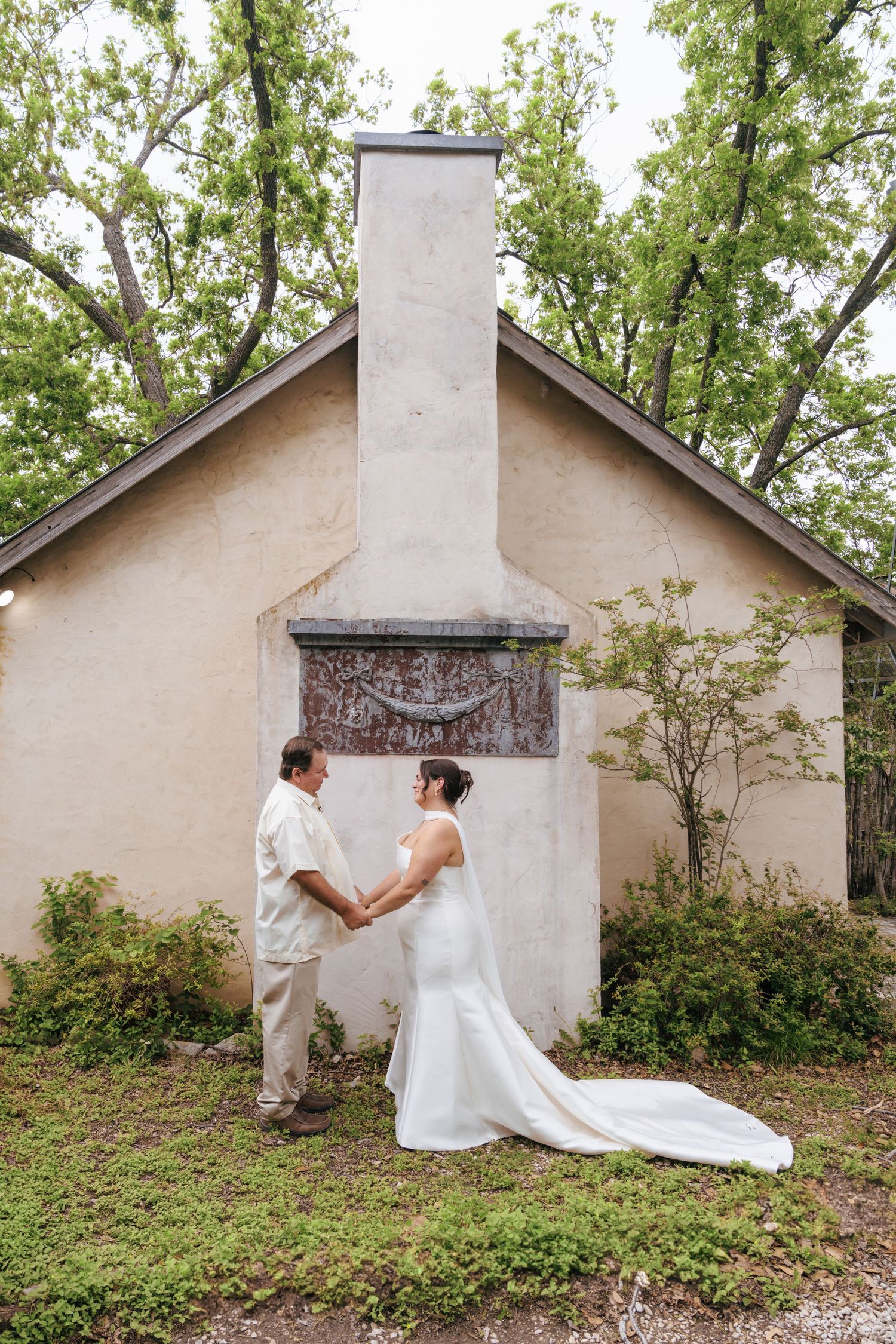 A romantic sequence of wedding photos showing a couple's first look and tender moments against a rustic white building.