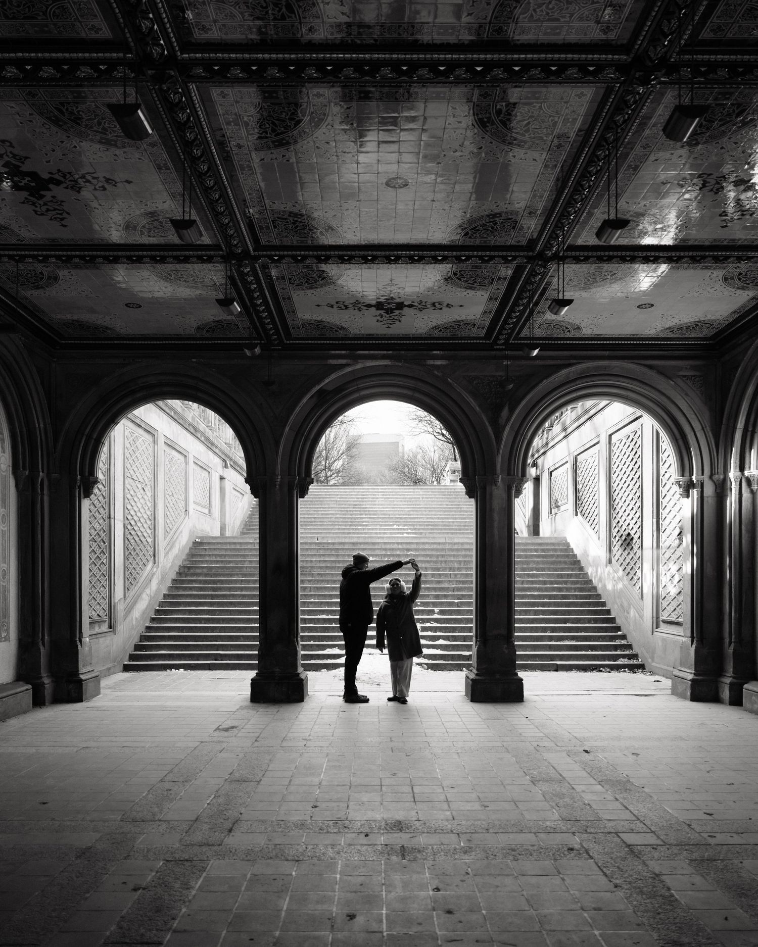 Black and white panoramic sequence of an empty archway tunnel with stone columns and stairs in Central Park.