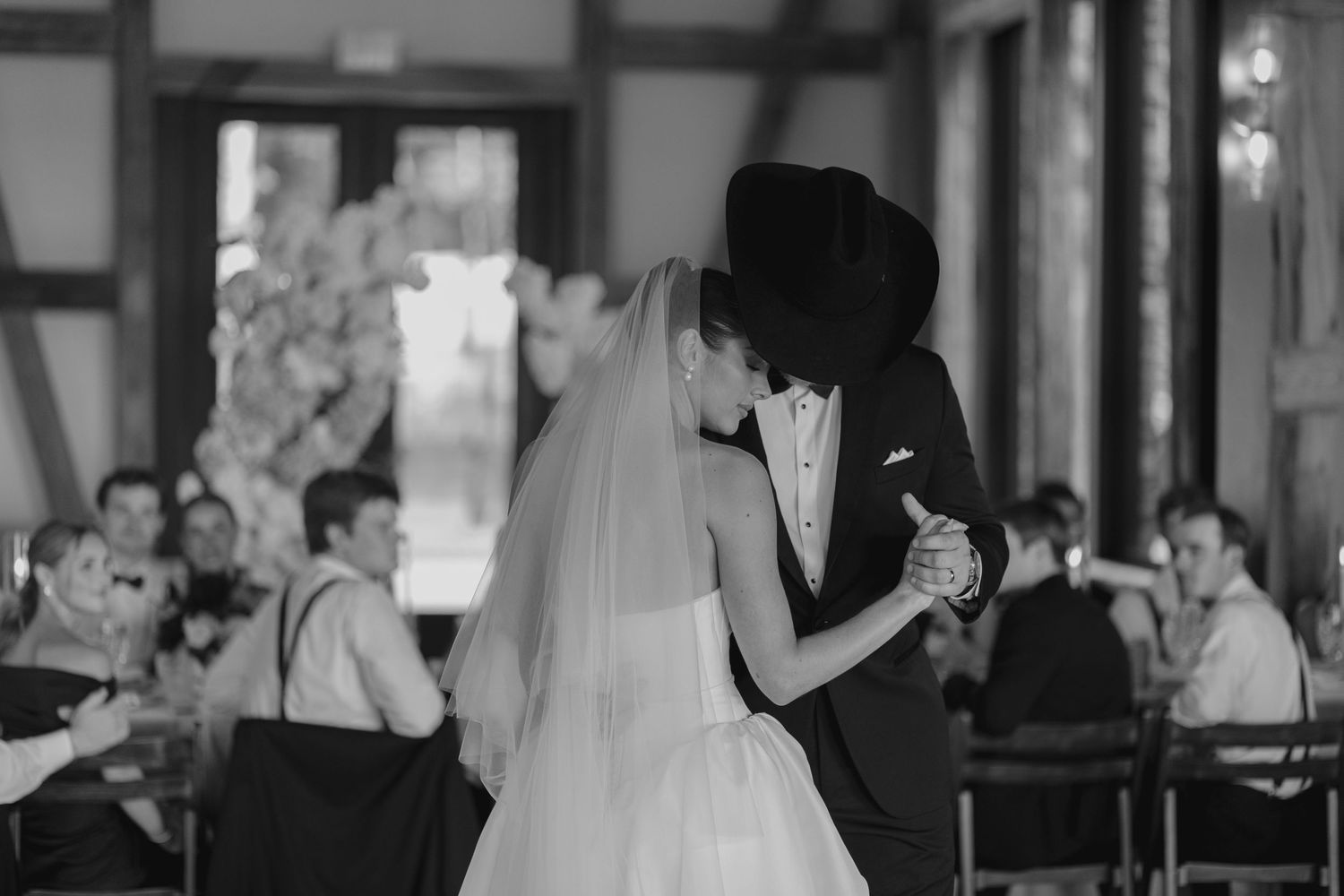 Wedding reception dance floor filled with guests in formal attire.