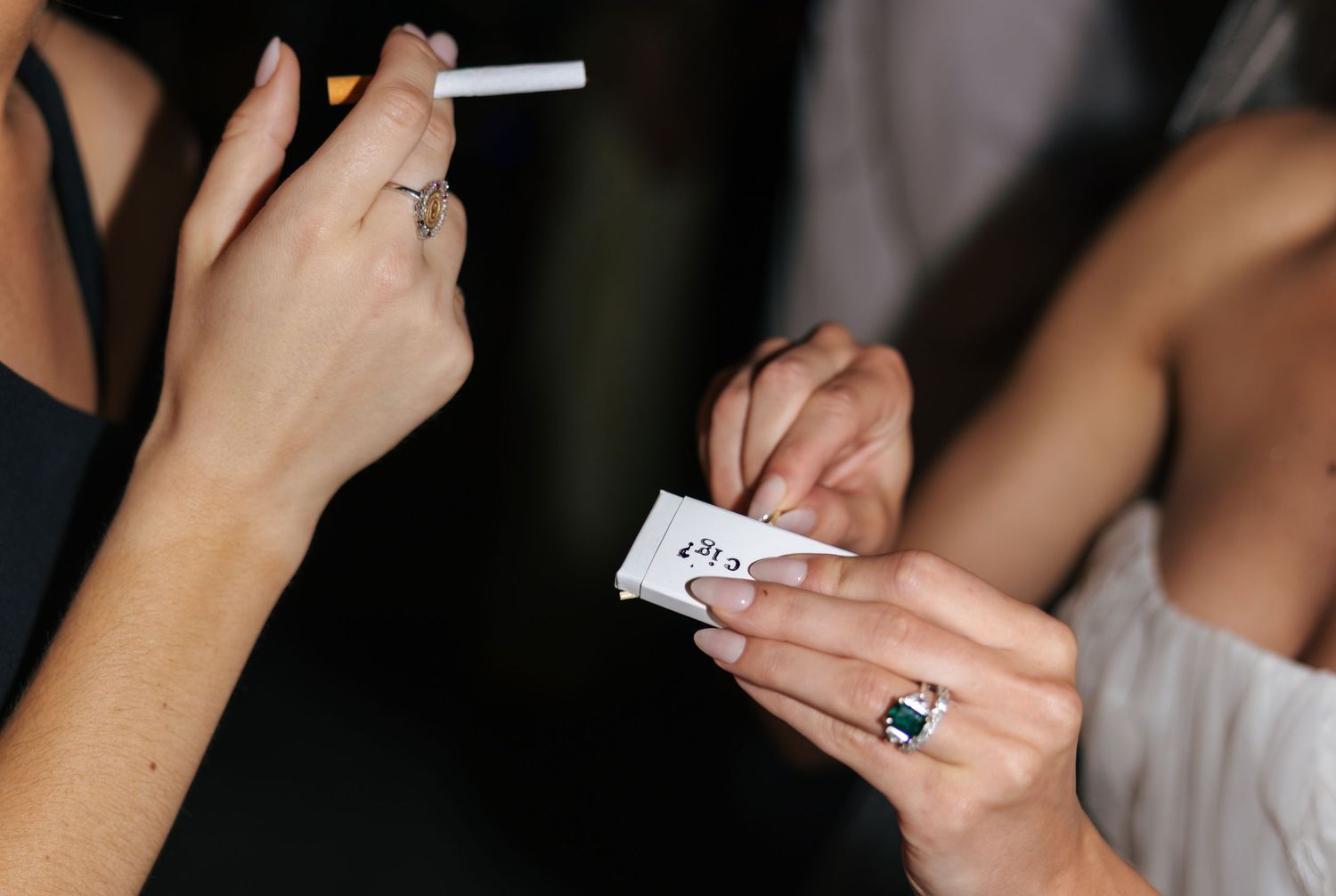 Close-up of hands holding a lit cigarette.