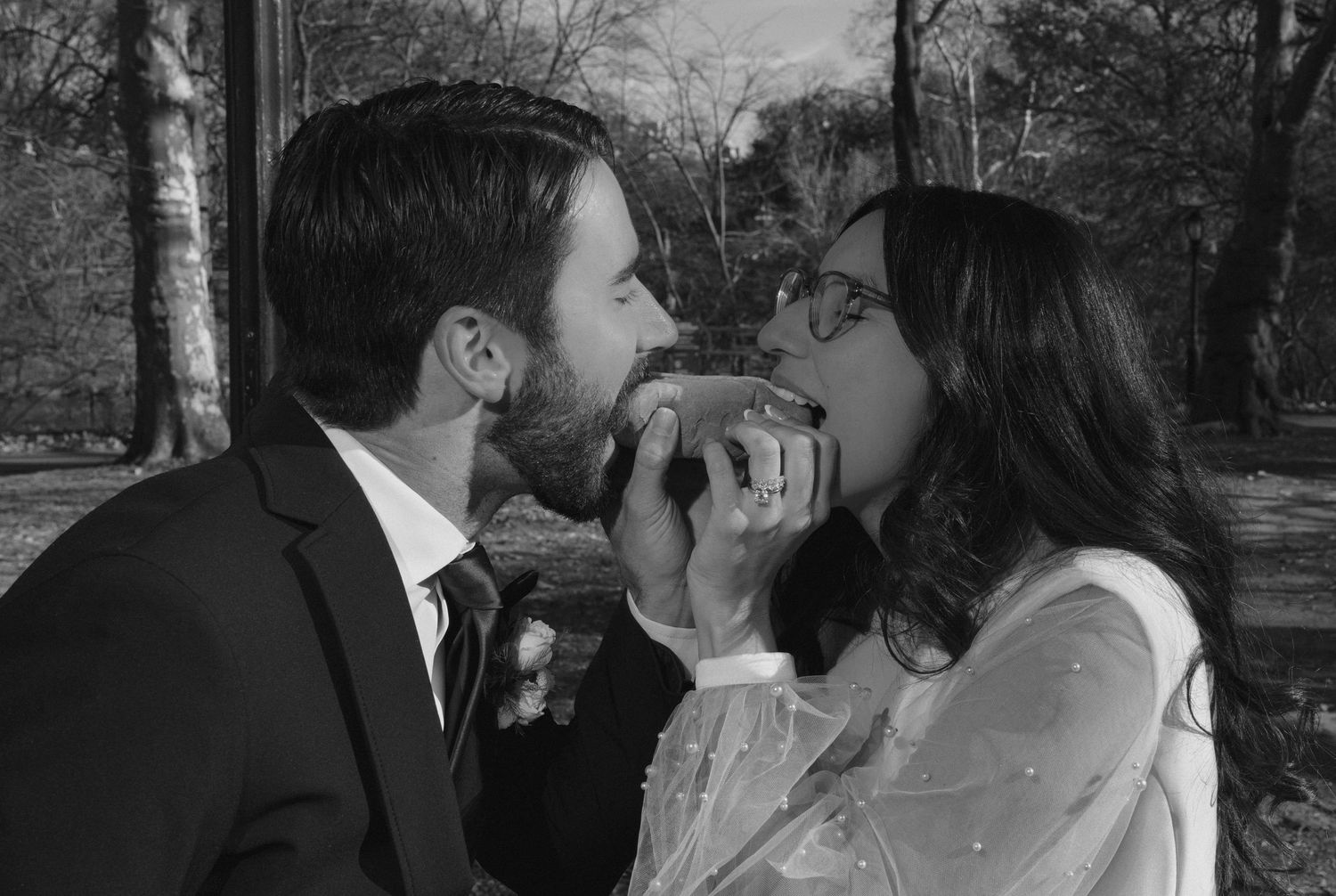 A series of black and white photos showing romantic wedding kisses in an outdoor setting with trees in the background.