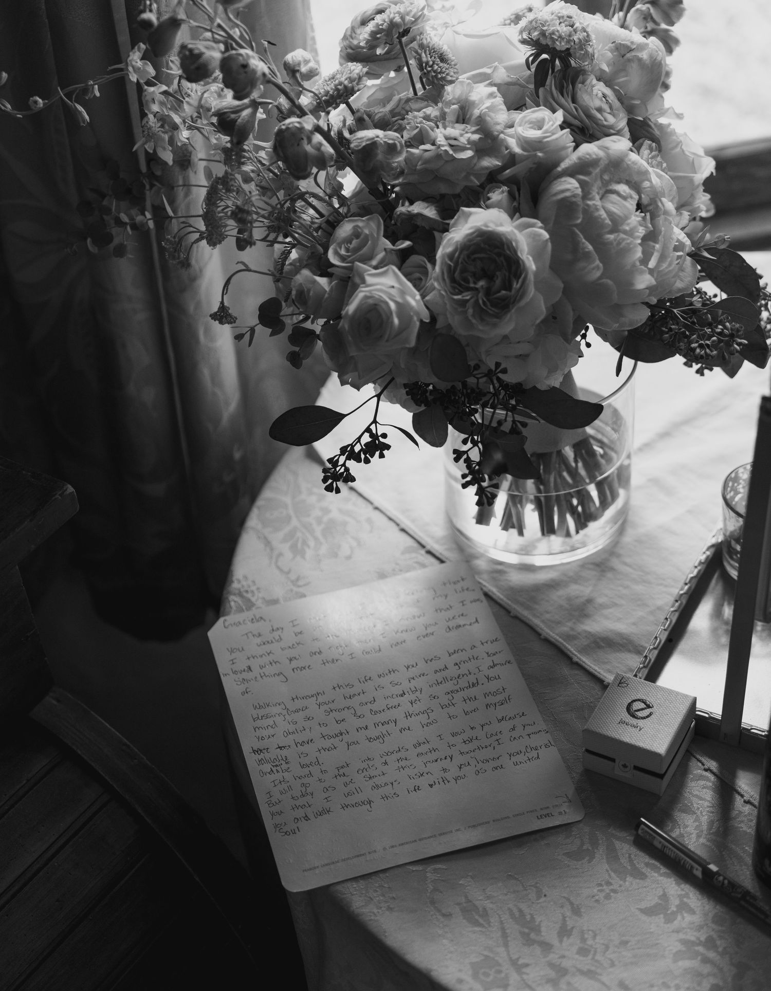 A black and white photo series showing handwritten notes next to a vase of flowers on a table.