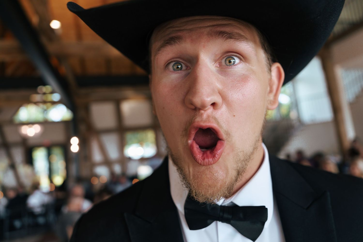 Wedding guest making an animated expression during reception celebrations.
