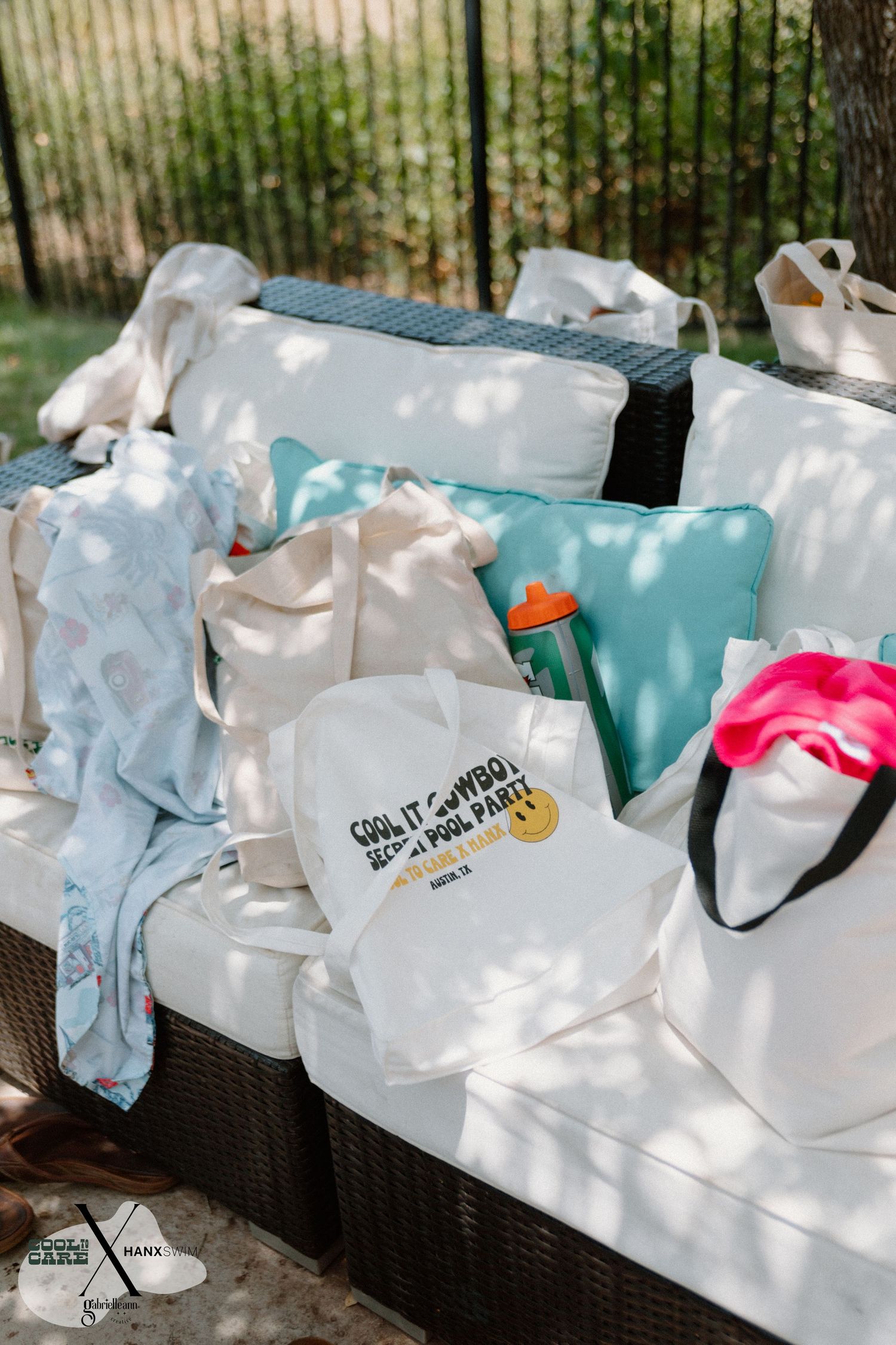 Row of light blue and white gift bags arranged on outdoor furniture.