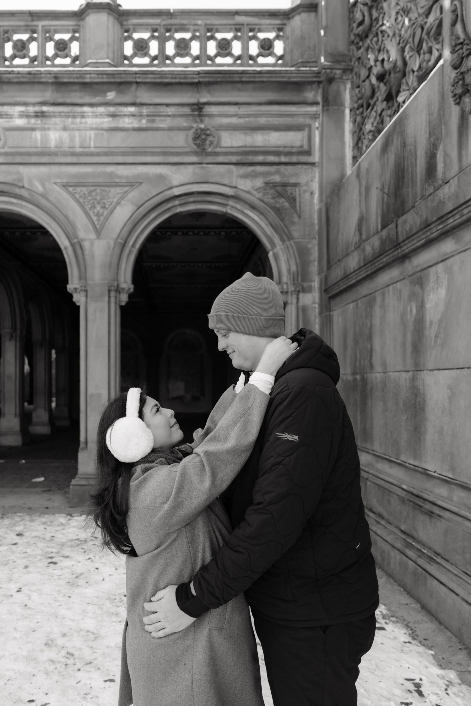 A series of romantic engagement photos taken in an ornate stone archway with decorative architecture.