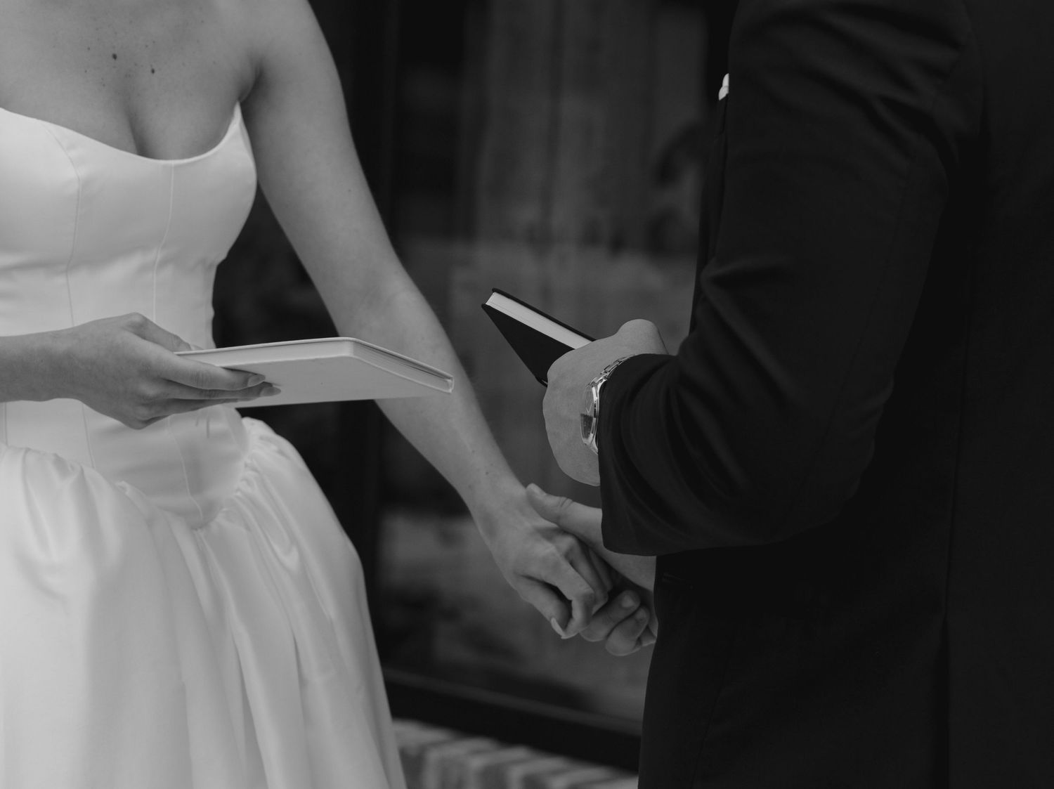 Black and white candid shot of a couple sharing an intimate moment at their wedding.