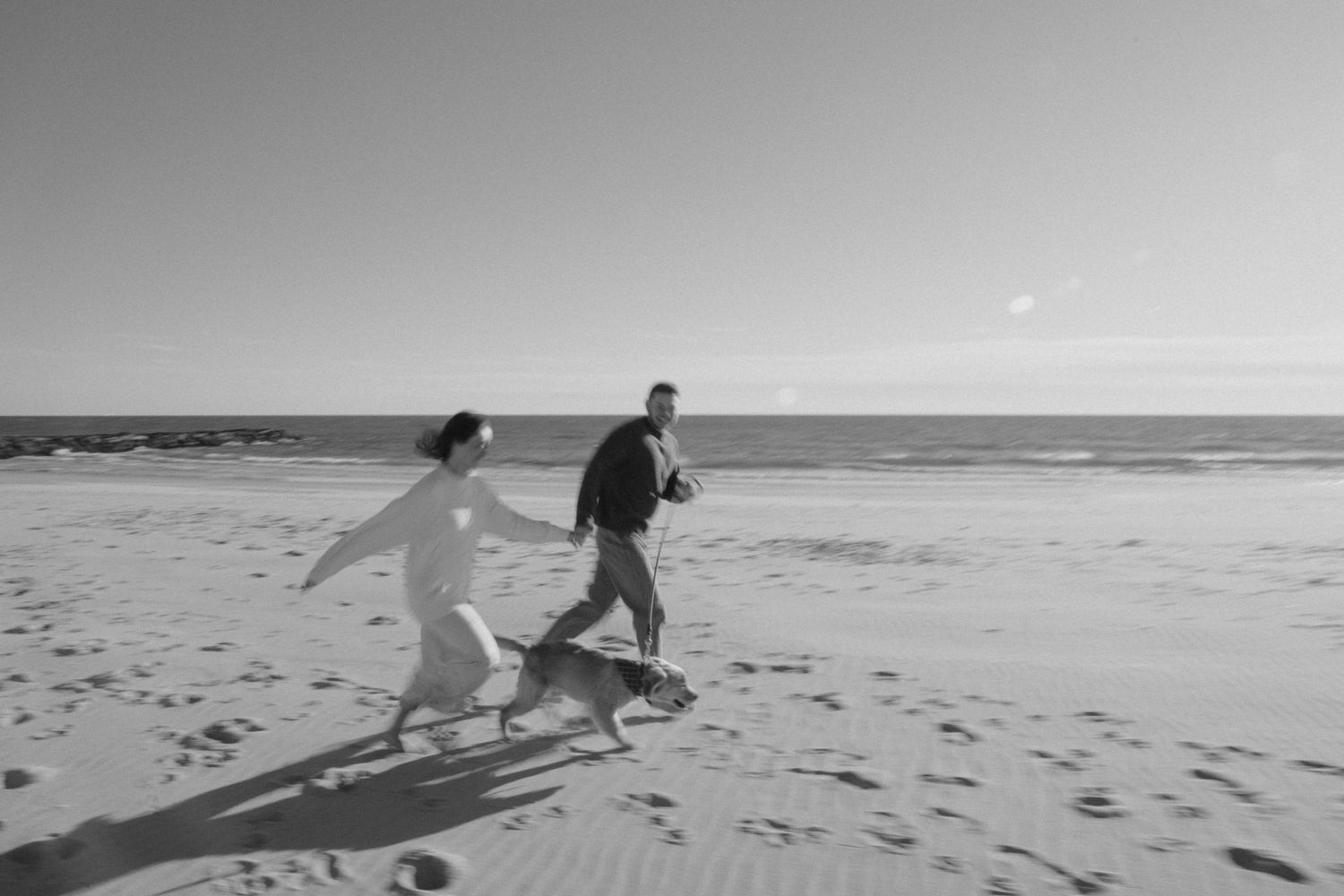 A series of black and white beach photographs showing surfers walking along the shoreline with surfboards.