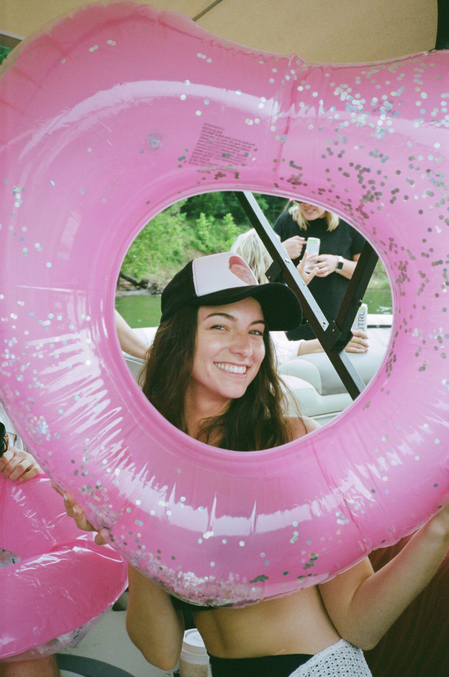A sequence of photos showing a pink glittery pool float being held up in different angles against a bright background.