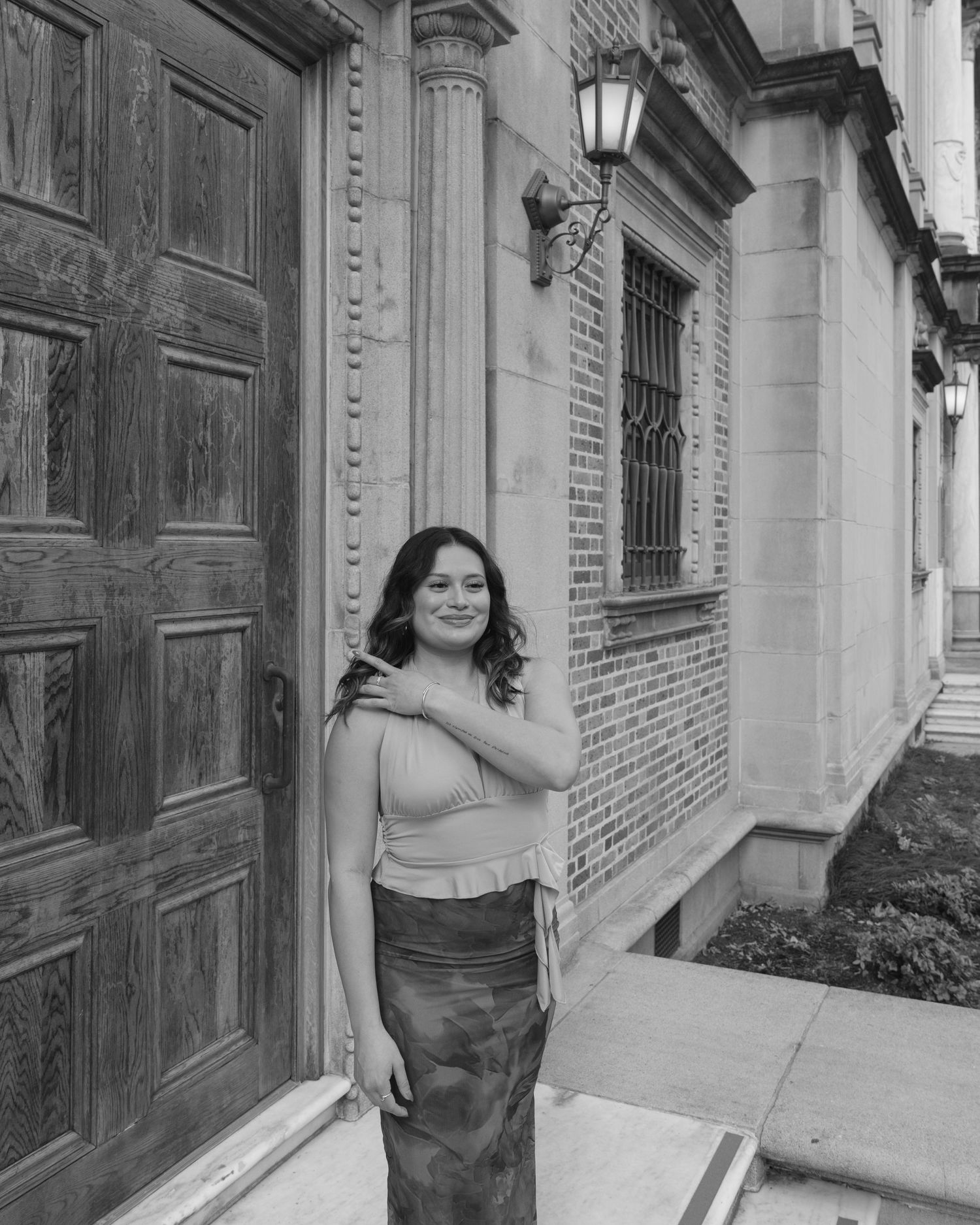 A series of black and white photos showing someone posing against a brick wall with columns and doorways.