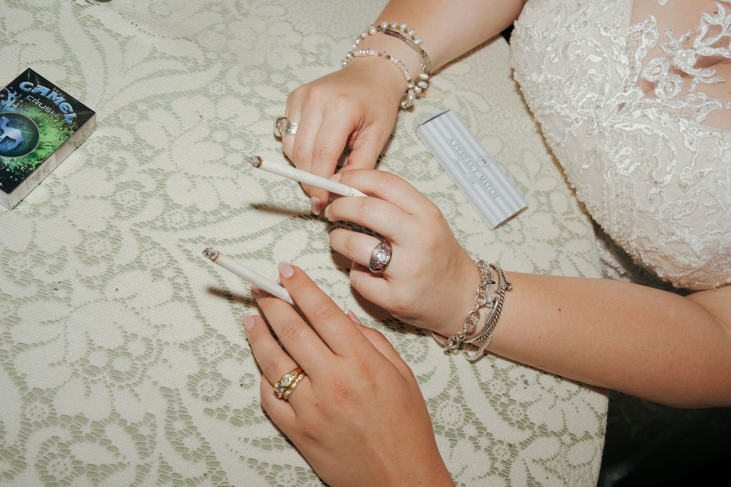 A close-up view of hands putting on delicate pearl jewelry and accessories.