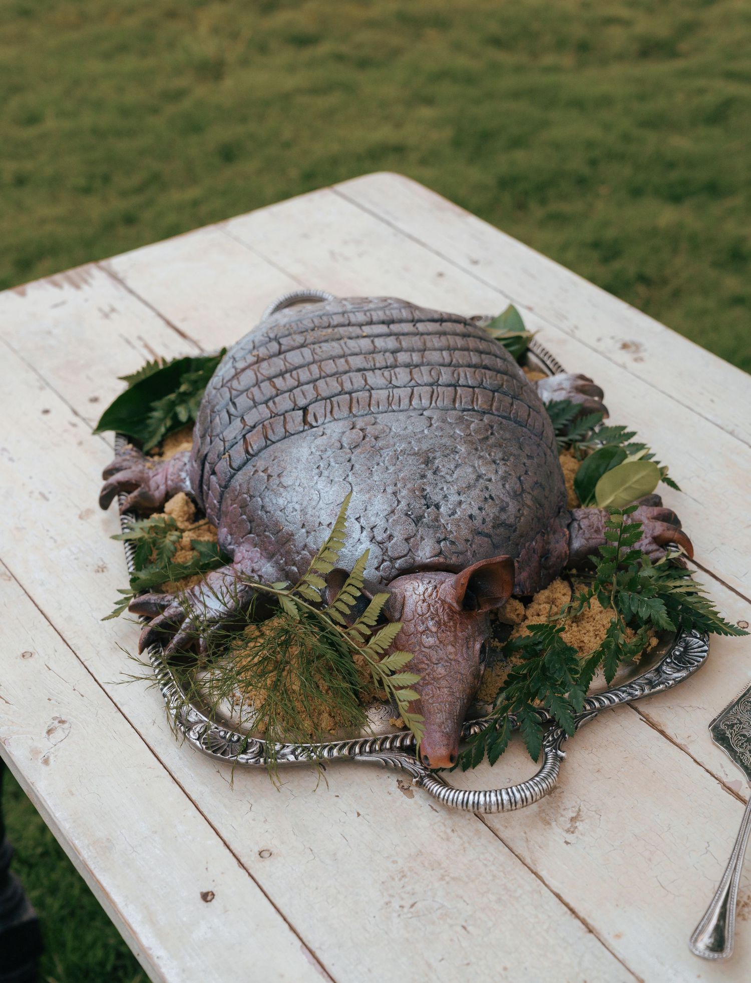 A raw turkey on a white wooden surface decorated with fresh herbs and garnishes for holiday preparation.