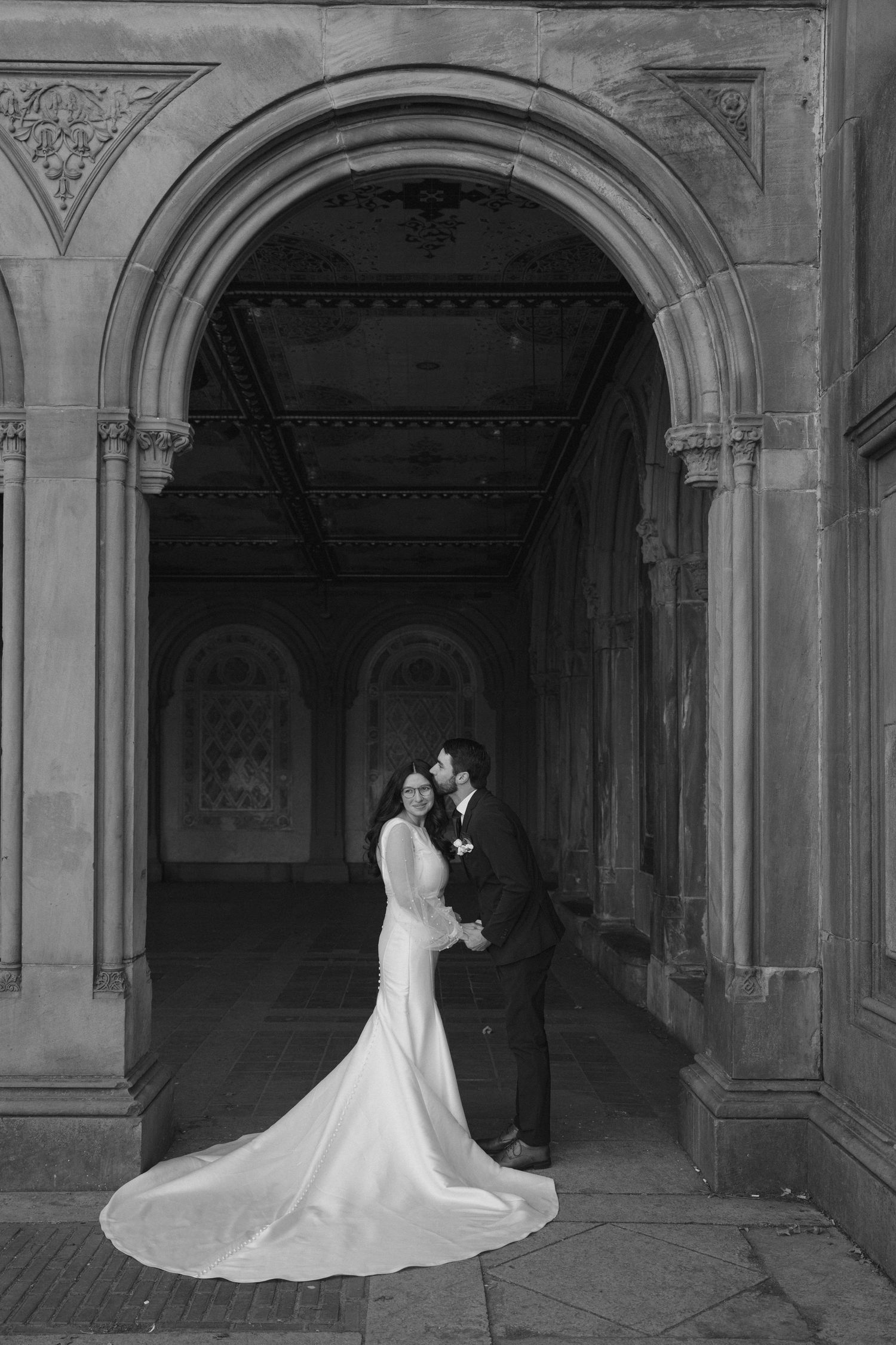 Elegant black and white wedding portraits in a gothic architectural setting.