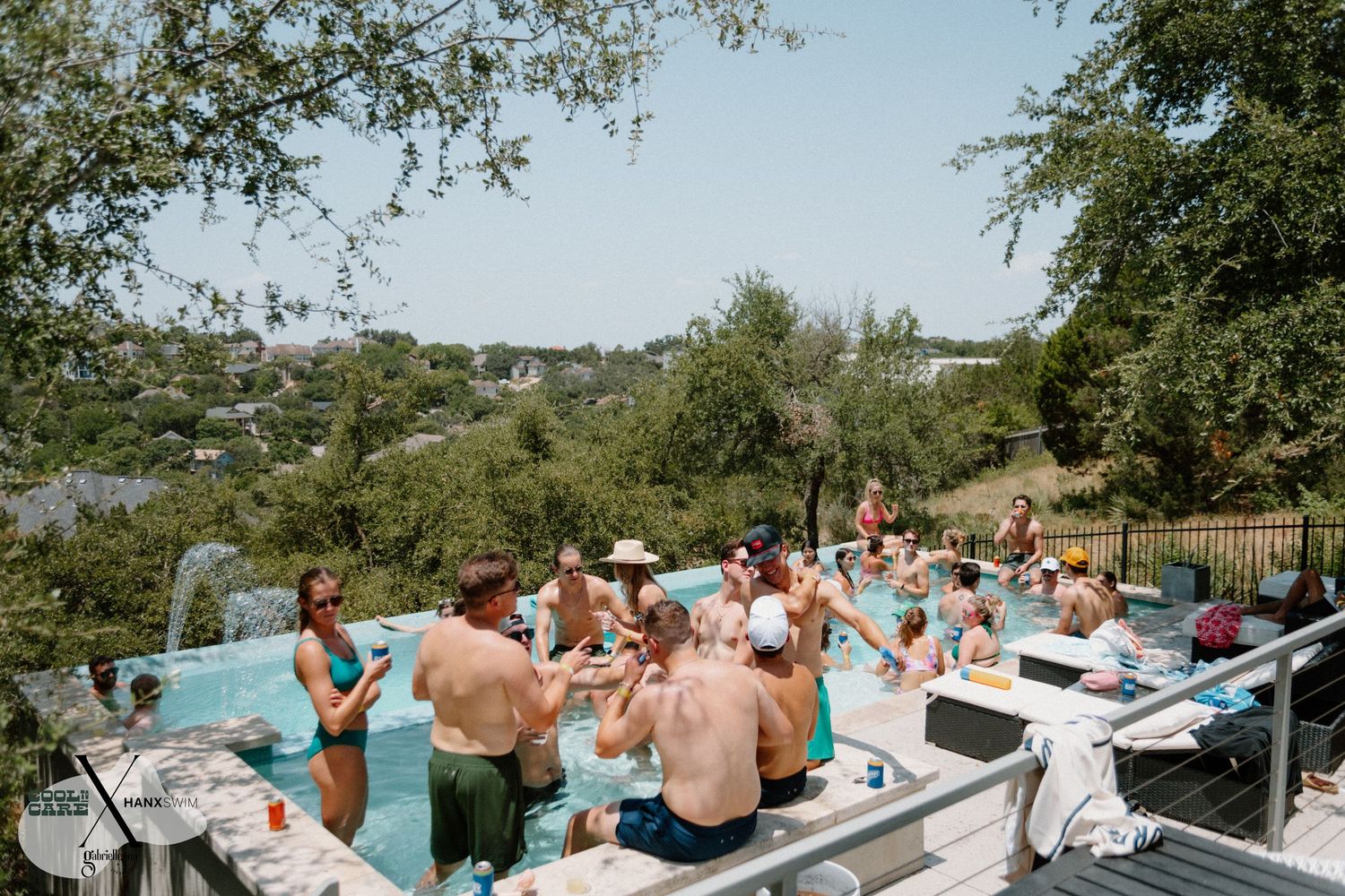 Outdoor pool party scene with guests lounging by the water on a sunny day.