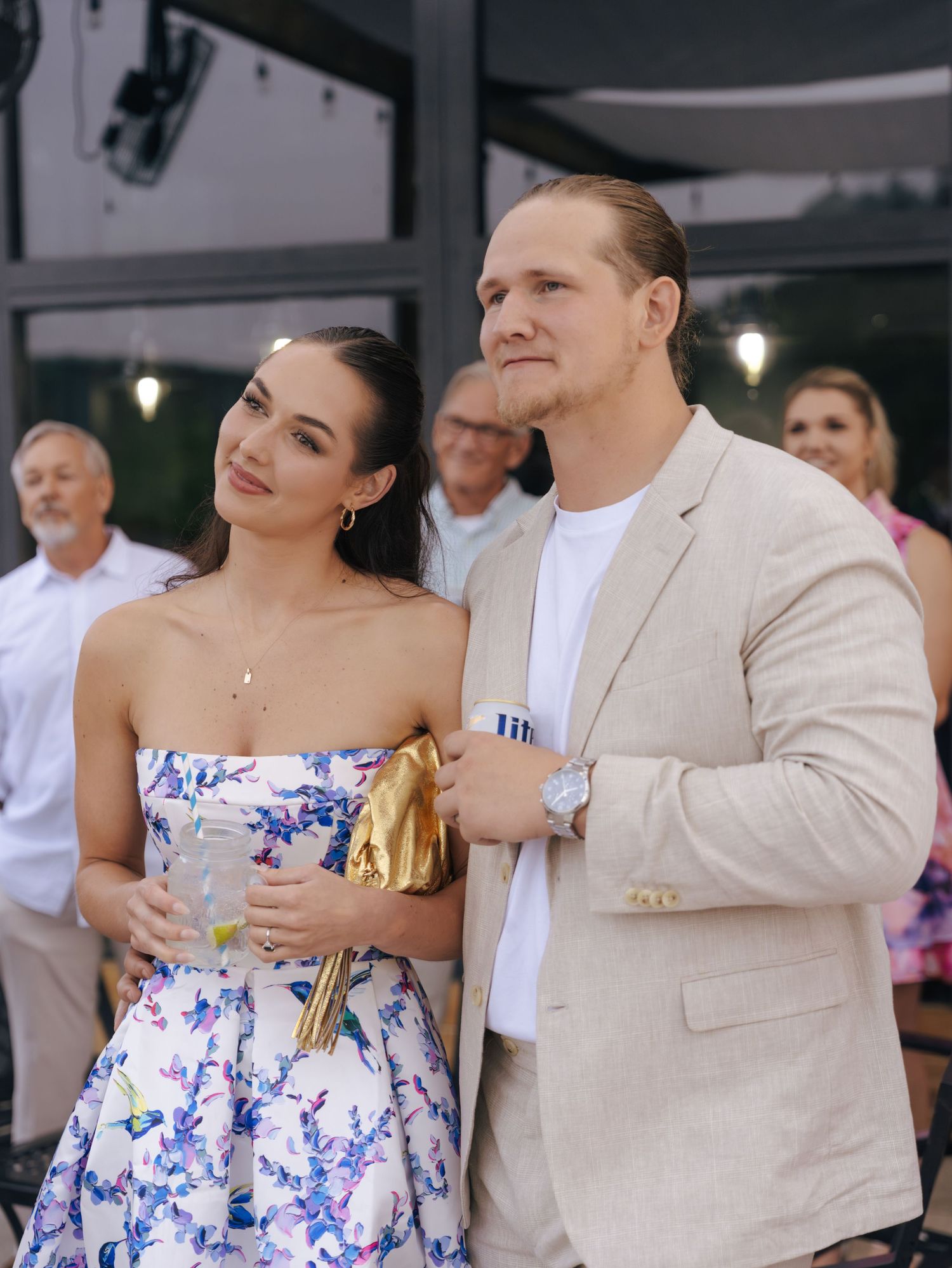 Couple dancing together at an outdoor event, with the woman wearing a blue and white floral dress.