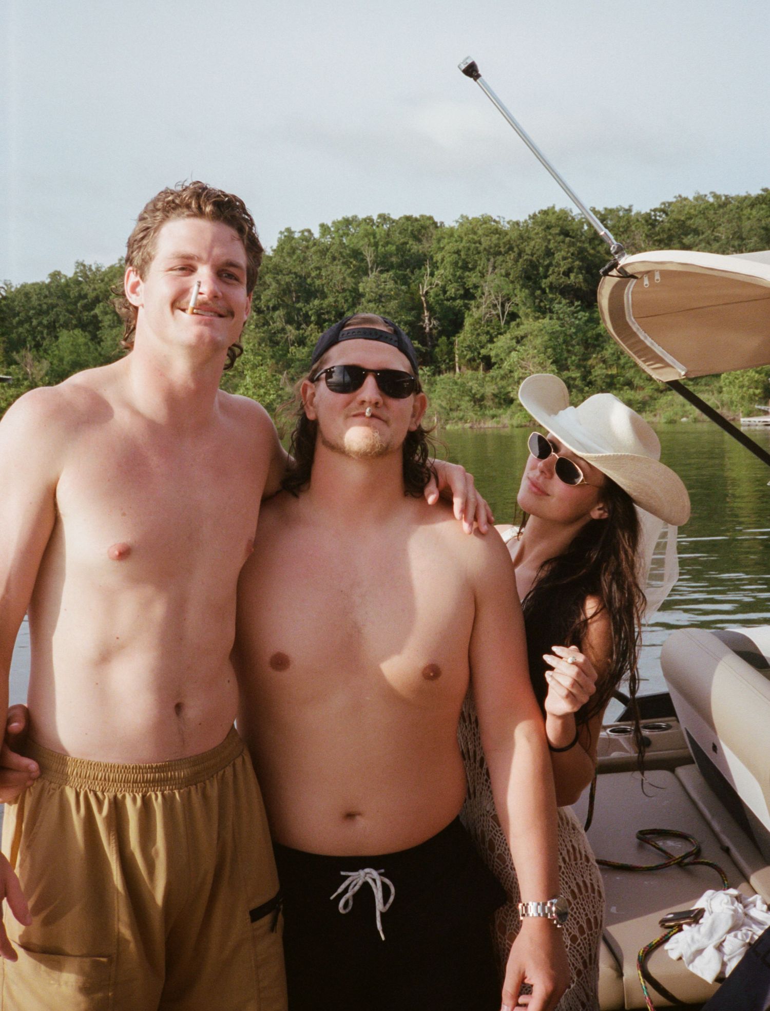 Three friends enjoying a sunny day on a boat at the lake.