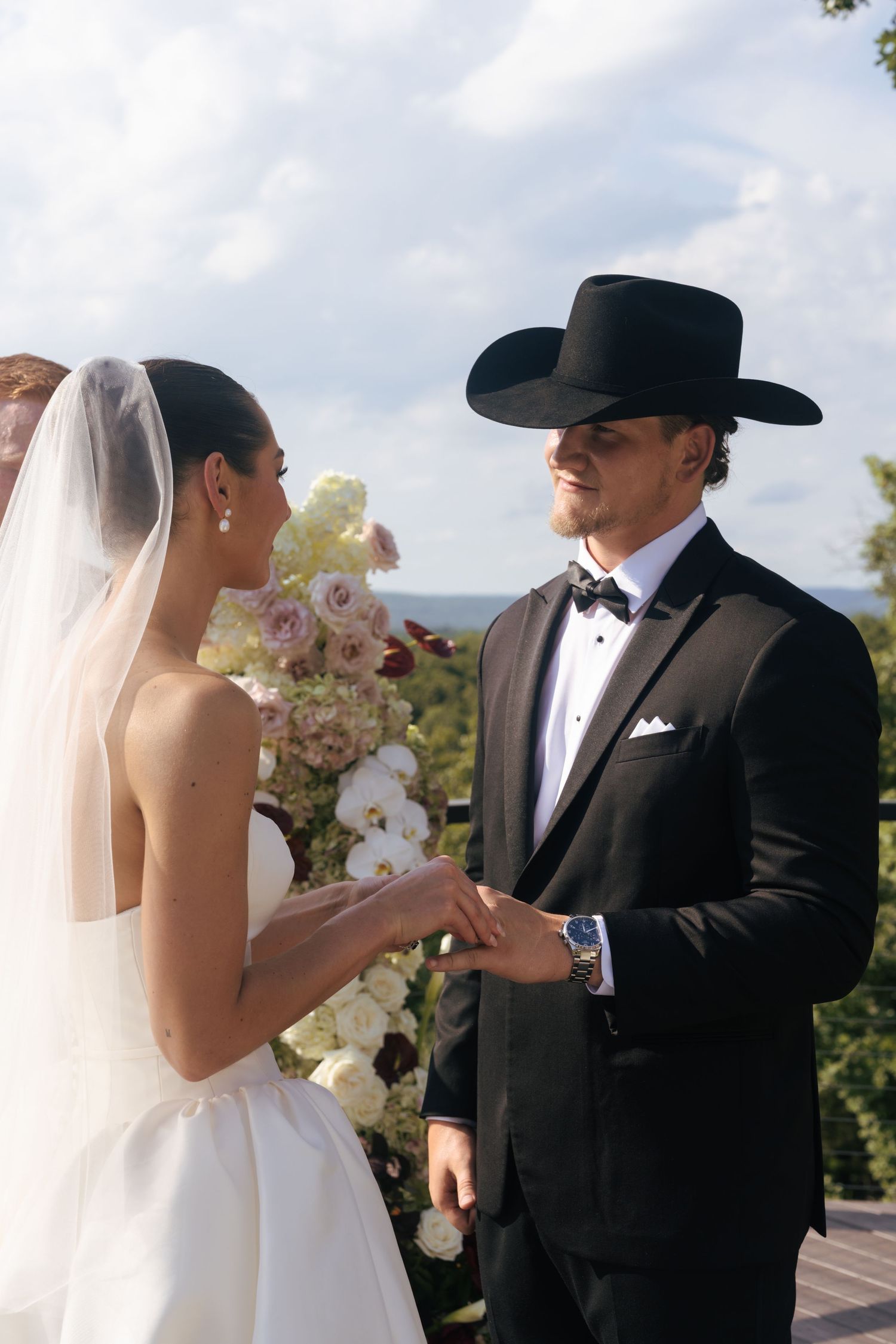 Wedding ceremony moment captured on a deck with mountain scenery in the background.