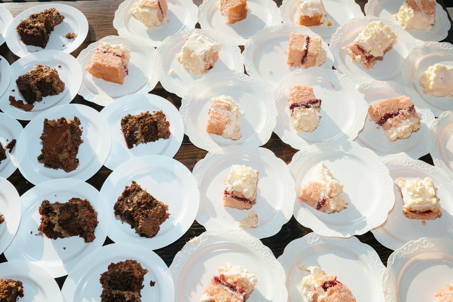 Overhead view of catered dessert bites arranged on white serving plates.